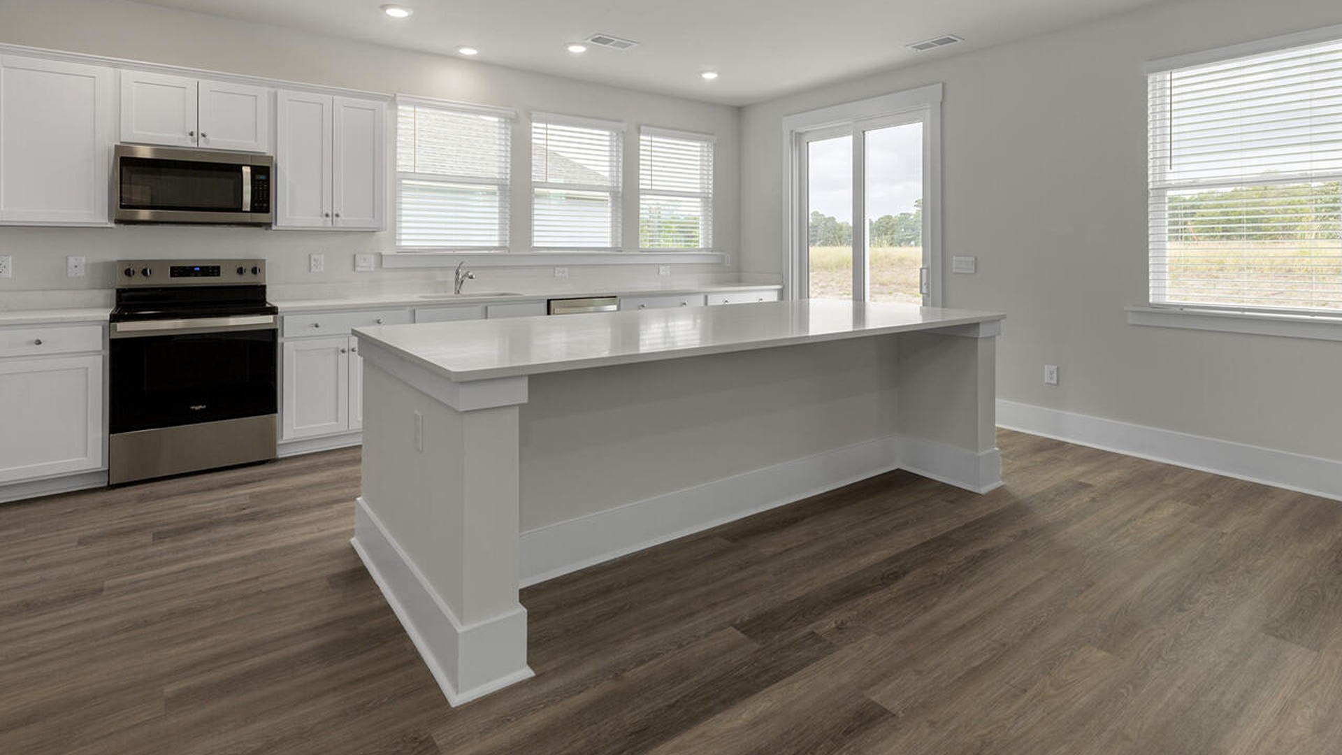 A large kitchen featuring granite countertops, stainless steel appliances and an island that offers ample room for food preparation and casual dining