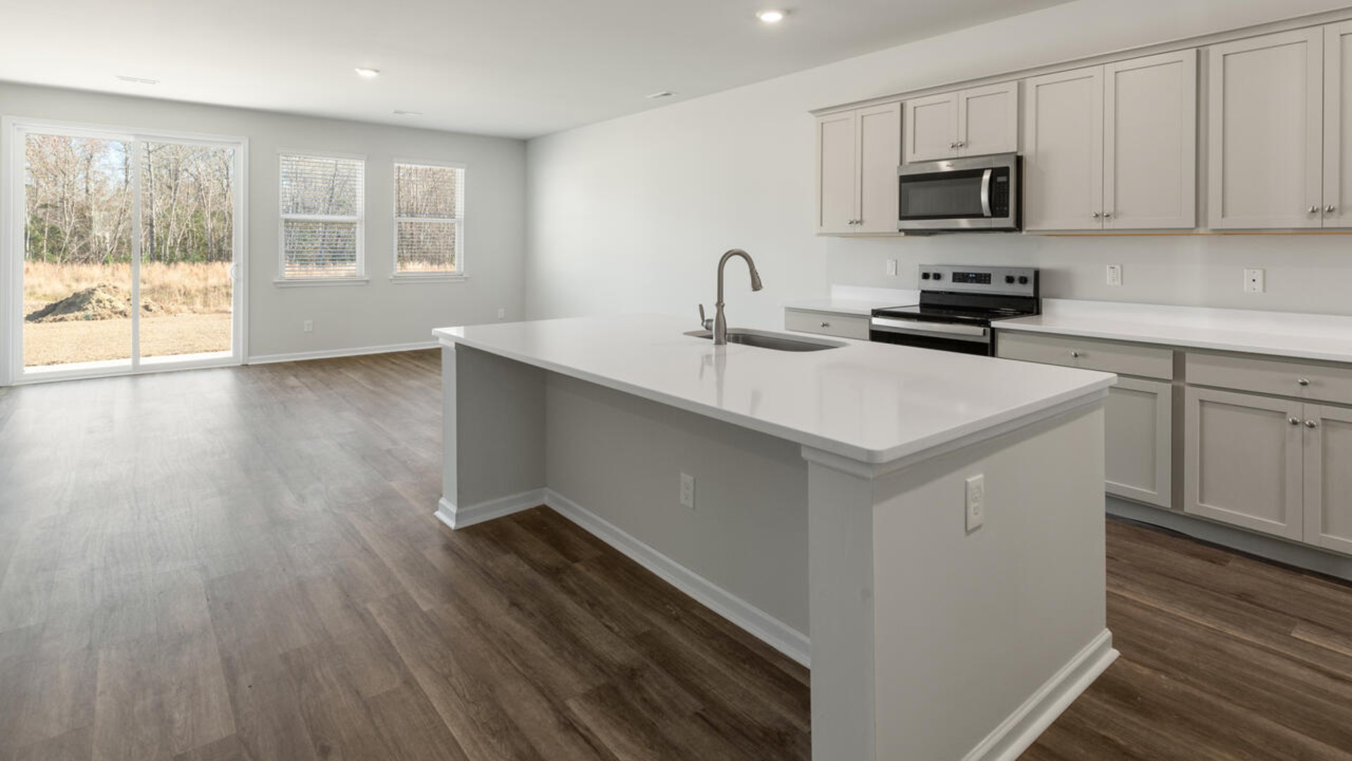 The kitchen features shaker-style cabinets, quartz countertops, and stainless steel appliances, which are sure to both turn heads and make meal prep easy. You’ll never be too far from the action with the living and dining area right there.