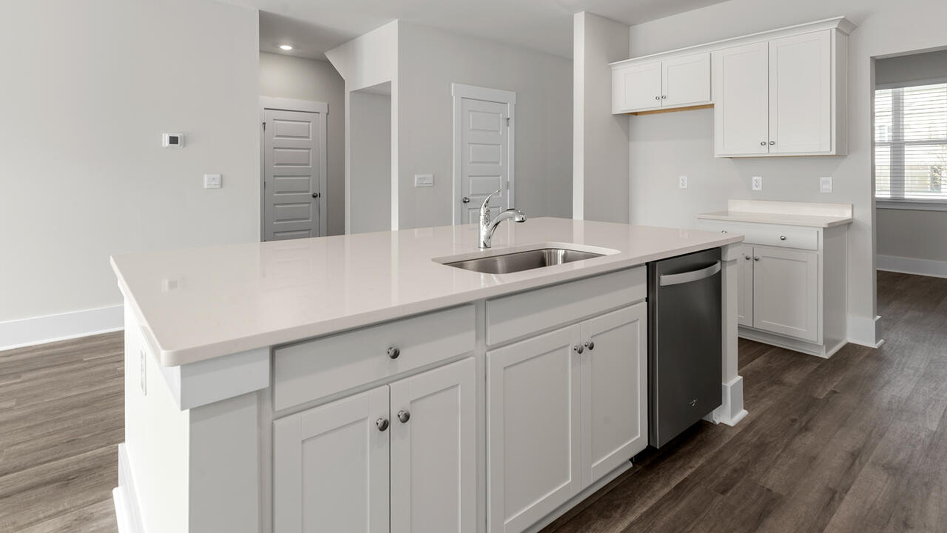 open concept kitchen and family room with additional seating at the large kitchen island, and a first floor primary bedroom retreat.