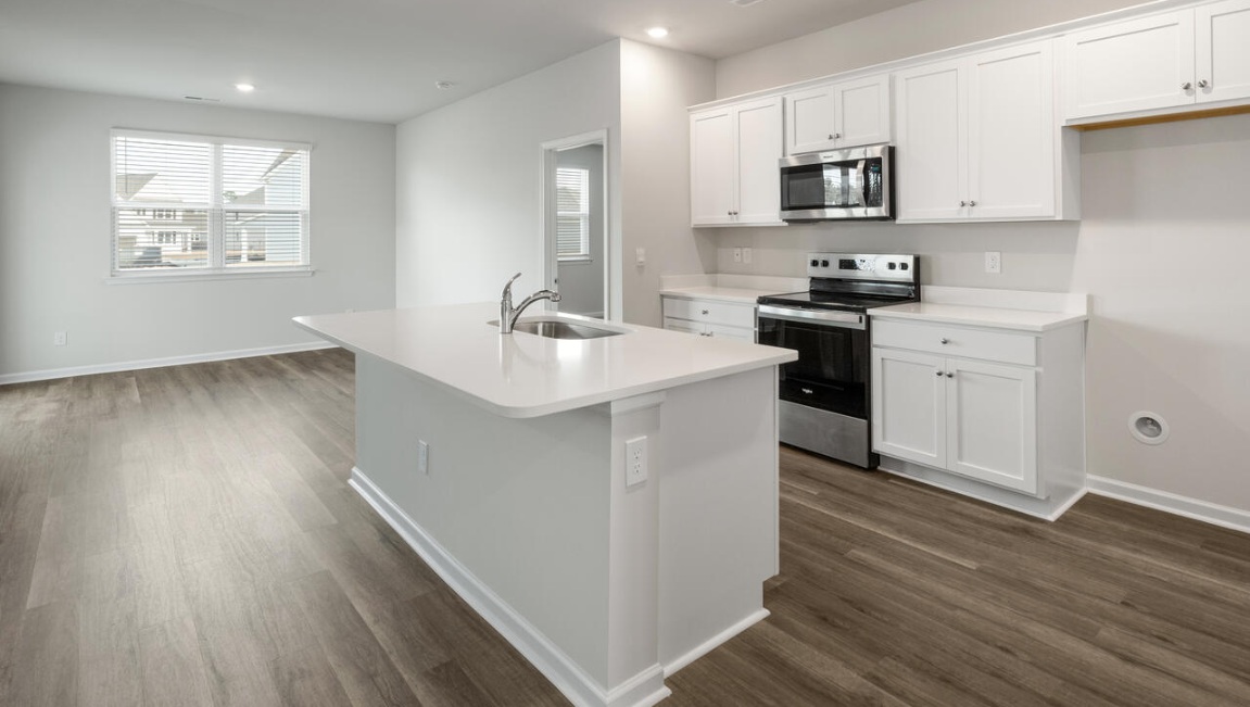 The kitchen features a large island, granite countertops, and stainless steel appliances, which are sure to both turn heads and make meal prep easy. You’ll never be too far from the action with the living and dining area right there.