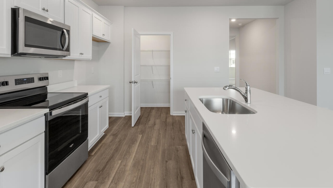 The kitchen features a large island, granite countertops, and stainless steel appliances, which are sure to both turn heads and make meal prep easy. You’ll never be too far from the action with the living and dining area right there.