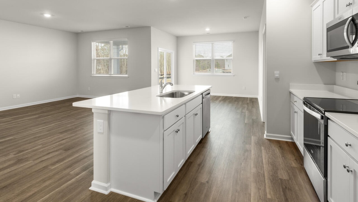 The kitchen features a large island, granite countertops, and stainless steel appliances, which are sure to both turn heads and make meal prep easy. You’ll never be too far from the action with the living and dining area right there.
