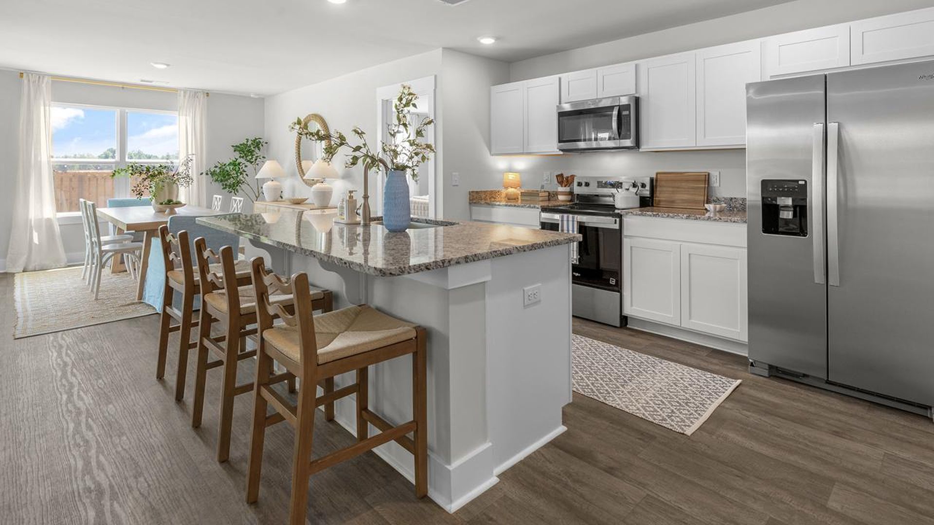 The kitchen features a large island, granite countertops, and stainless steel appliances