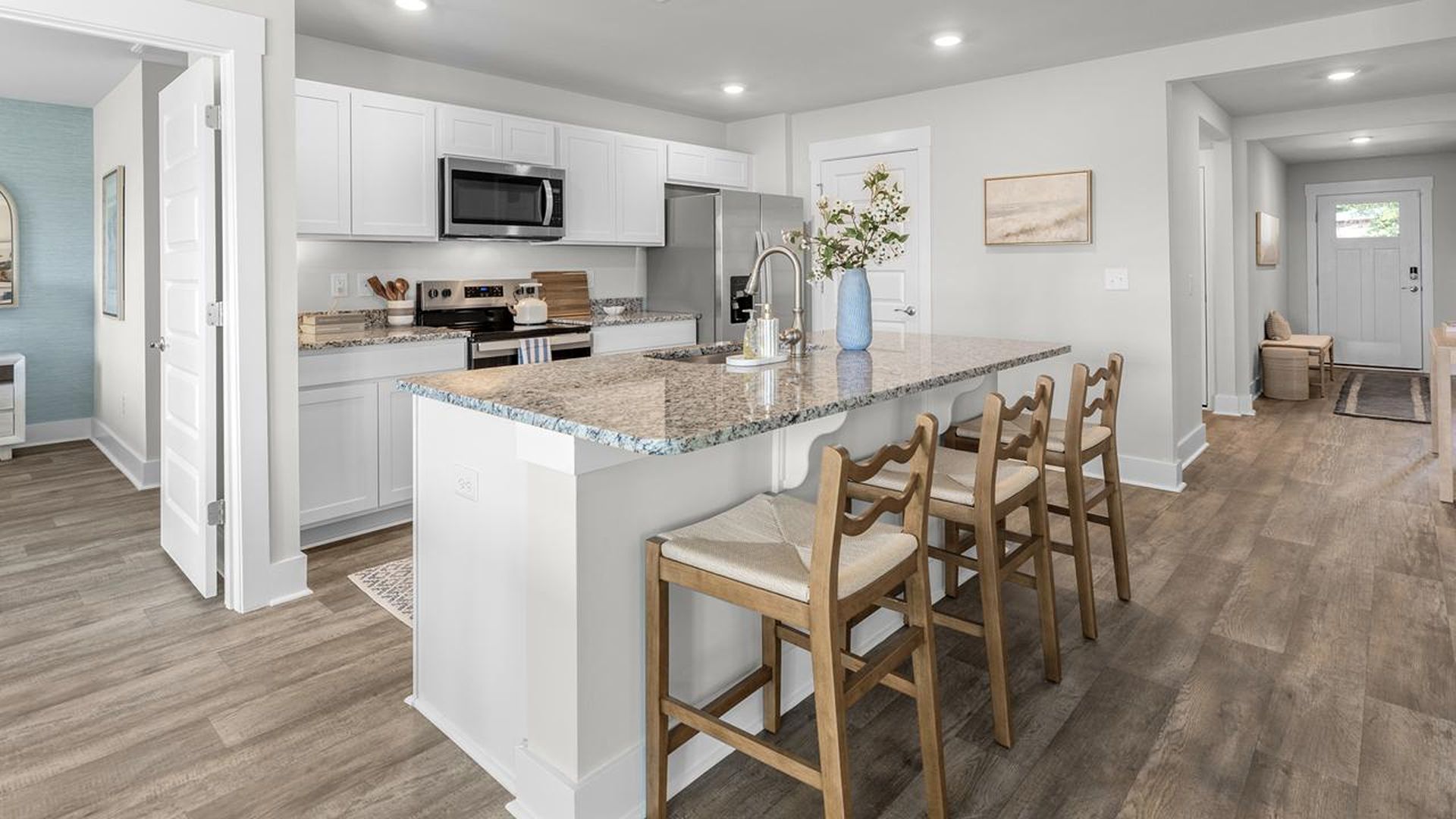 The kitchen features a large island, granite countertops, and stainless steel appliances