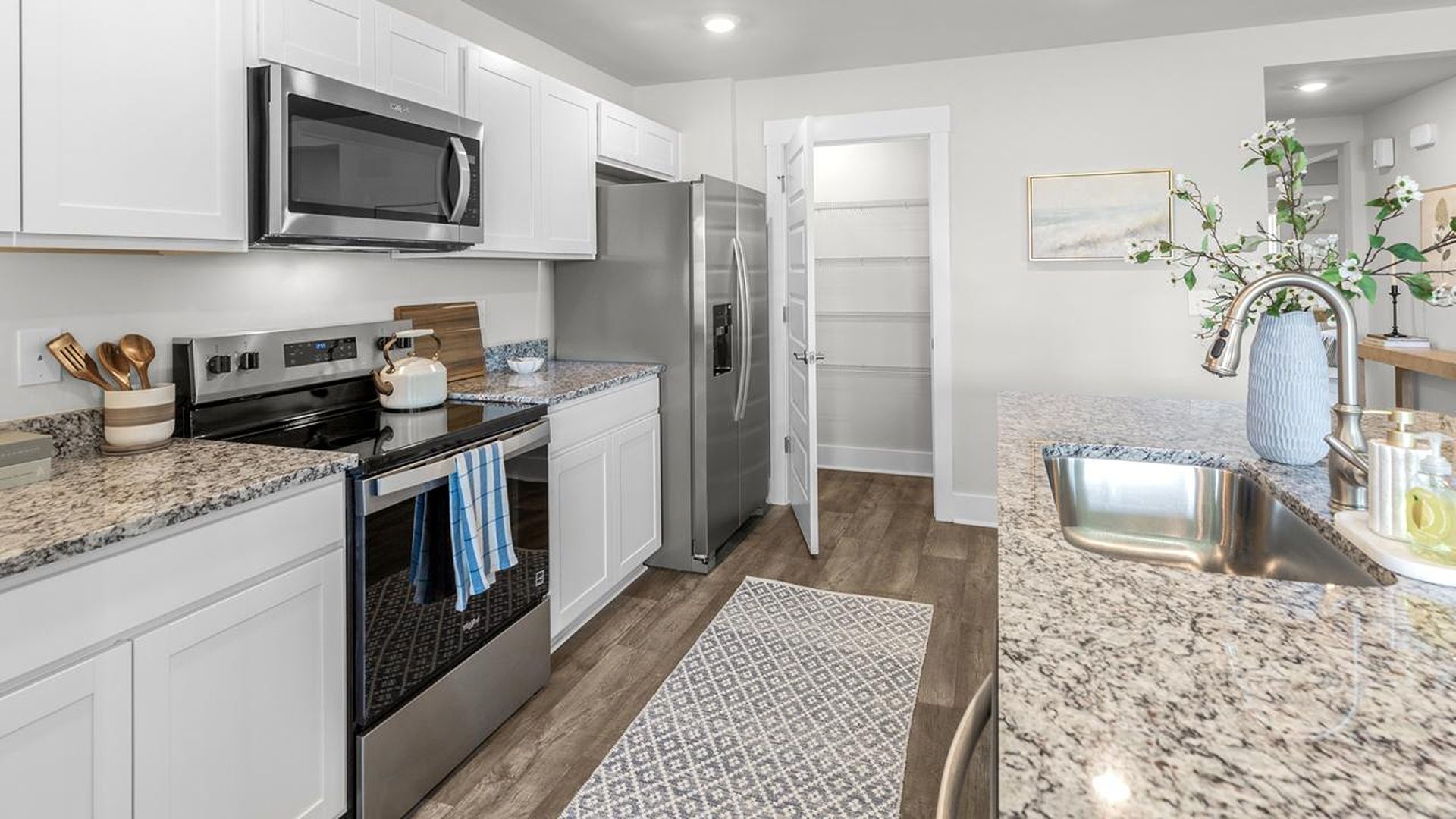 The kitchen features a large island, granite countertops, and stainless steel appliances