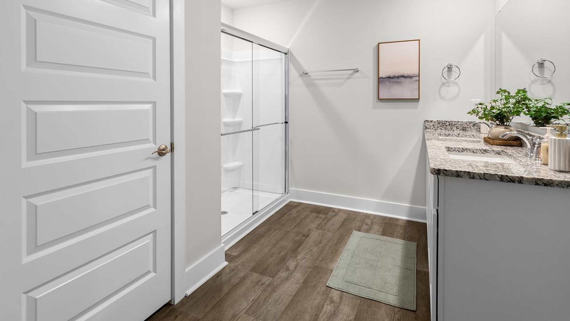 The Primary Suite offers a massive closet and a luxurious bathroom with a walk-in shower, linen closet, and dual vanity