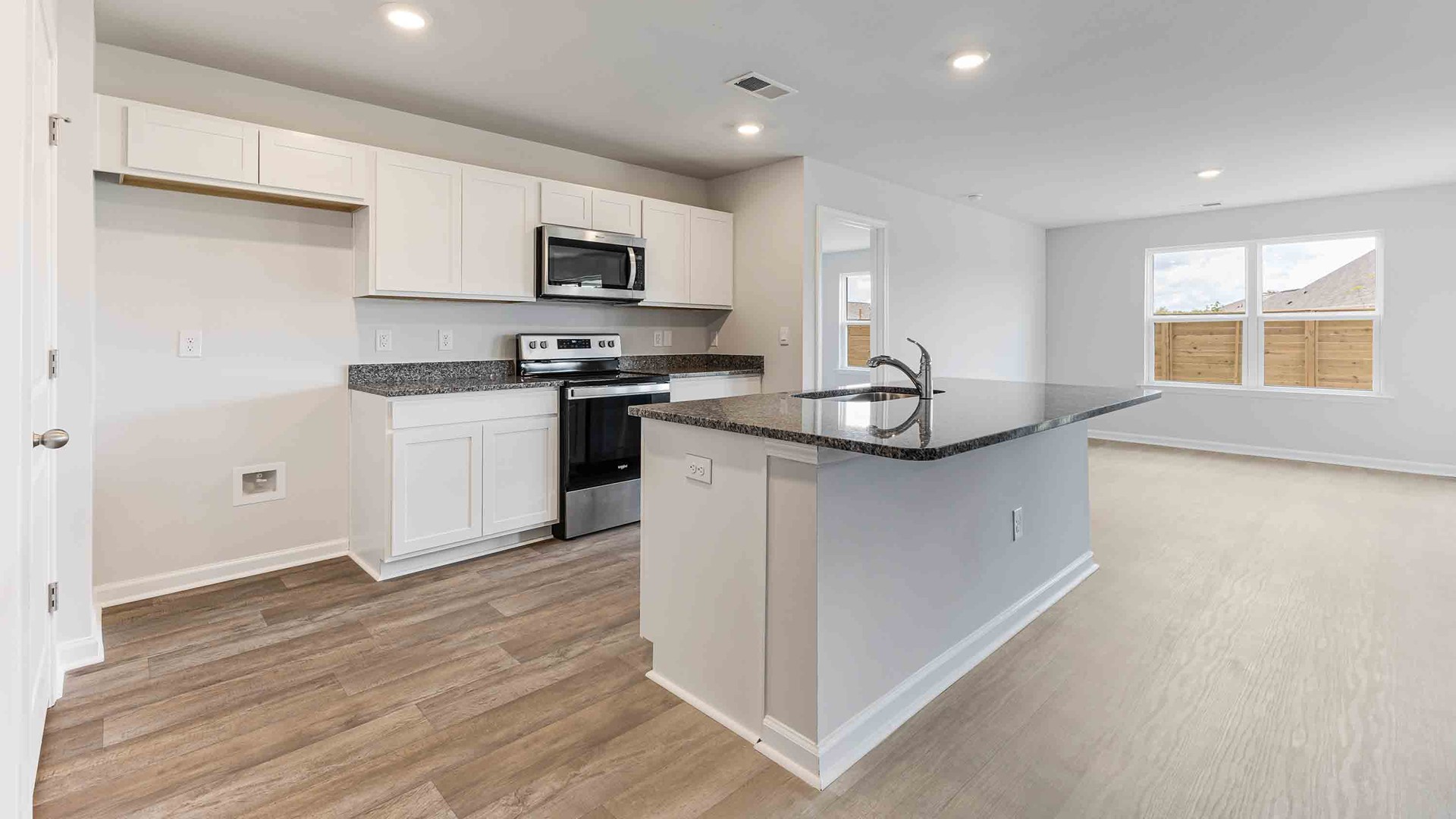 The kitchen features a large island, granite countertops, and stainless-steel appliances, which are sure to both turn heads and make meal prep easy. You’ll never be too far from the action with the living and dining area right there.