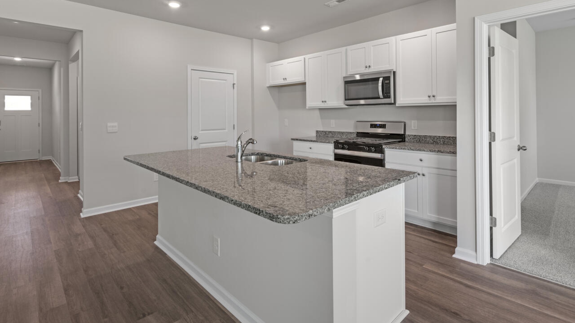 The kitchen features a large island, granite countertops, and stainless-steel appliances, which are sure to both turn heads and make meal prep easy.