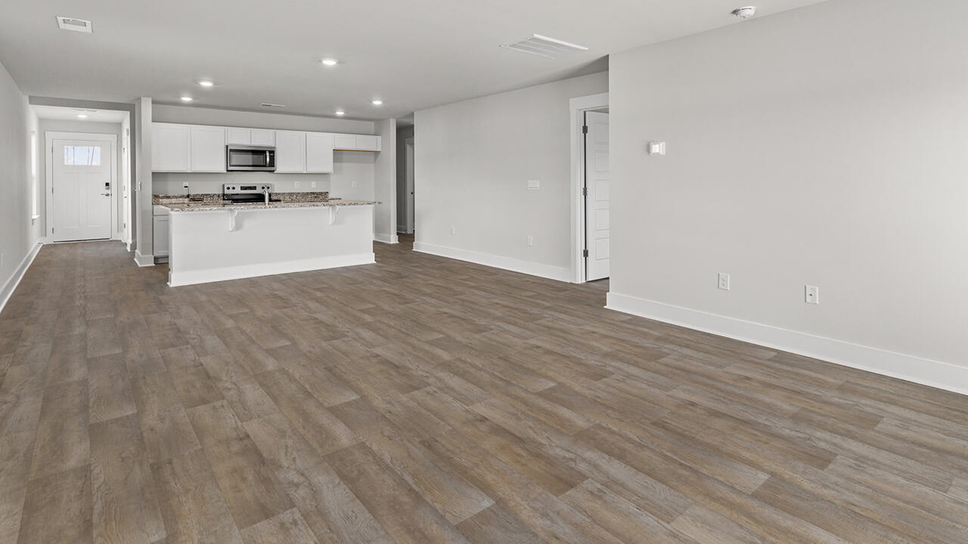 Entering the great room, we find the dining area, family room and a wonderful cook's kitchen are all together for open living.