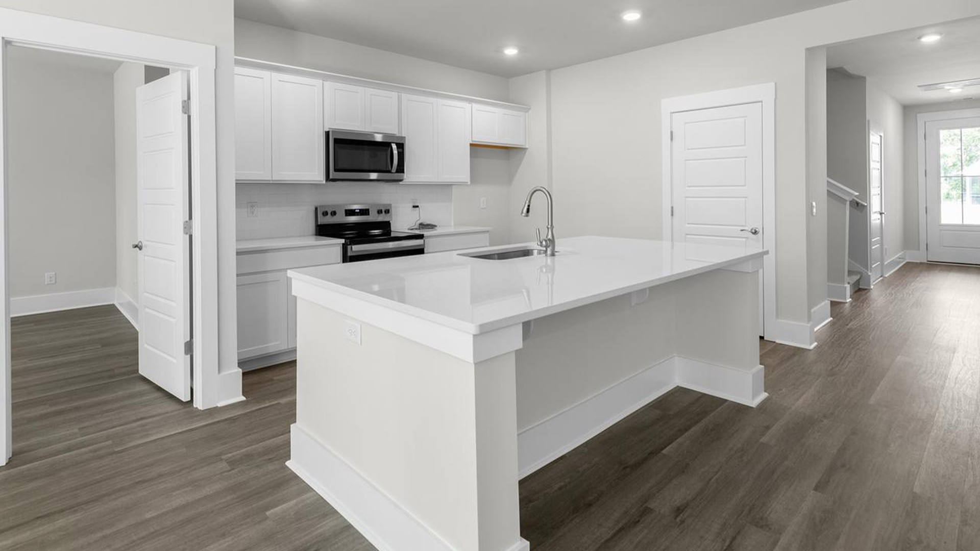 The kitchen offers quartz countertops, stainless steel appliances, a single bowl sink, and subway tile backsplash.