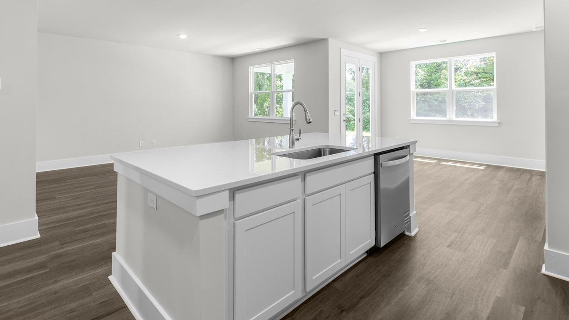 The kitchen offers quartz countertops, stainless steel appliances, a single bowl sink, and subway tile backsplash.