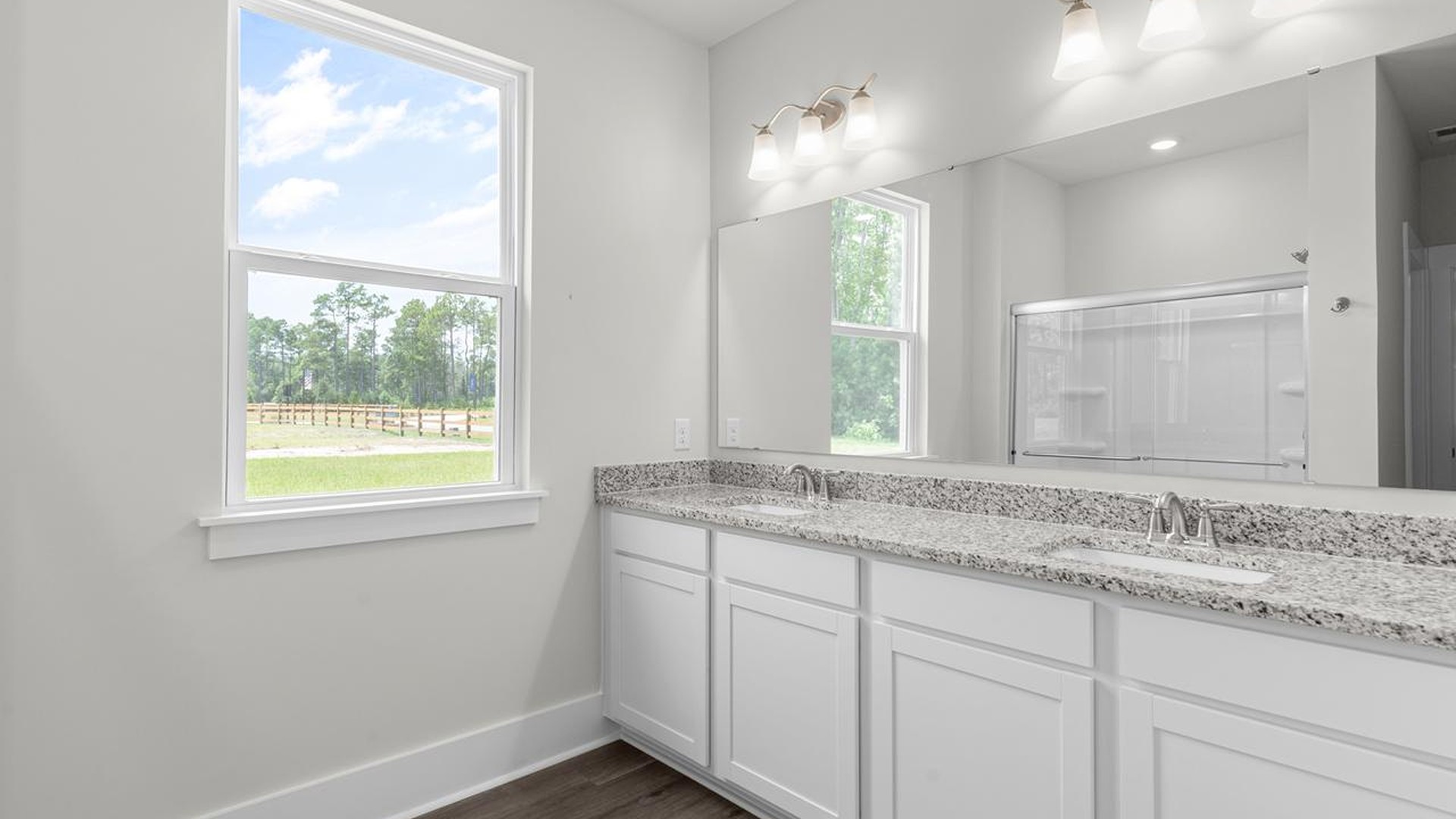 The downstairs primary suite includes a walk-in-closet and ensuite bath with a double vanity, walk-in-shower, and separate water closet. The guest ensuite upstairs provides tons of privacy and LVP flooring throughout the main level makes cleanups a breeze