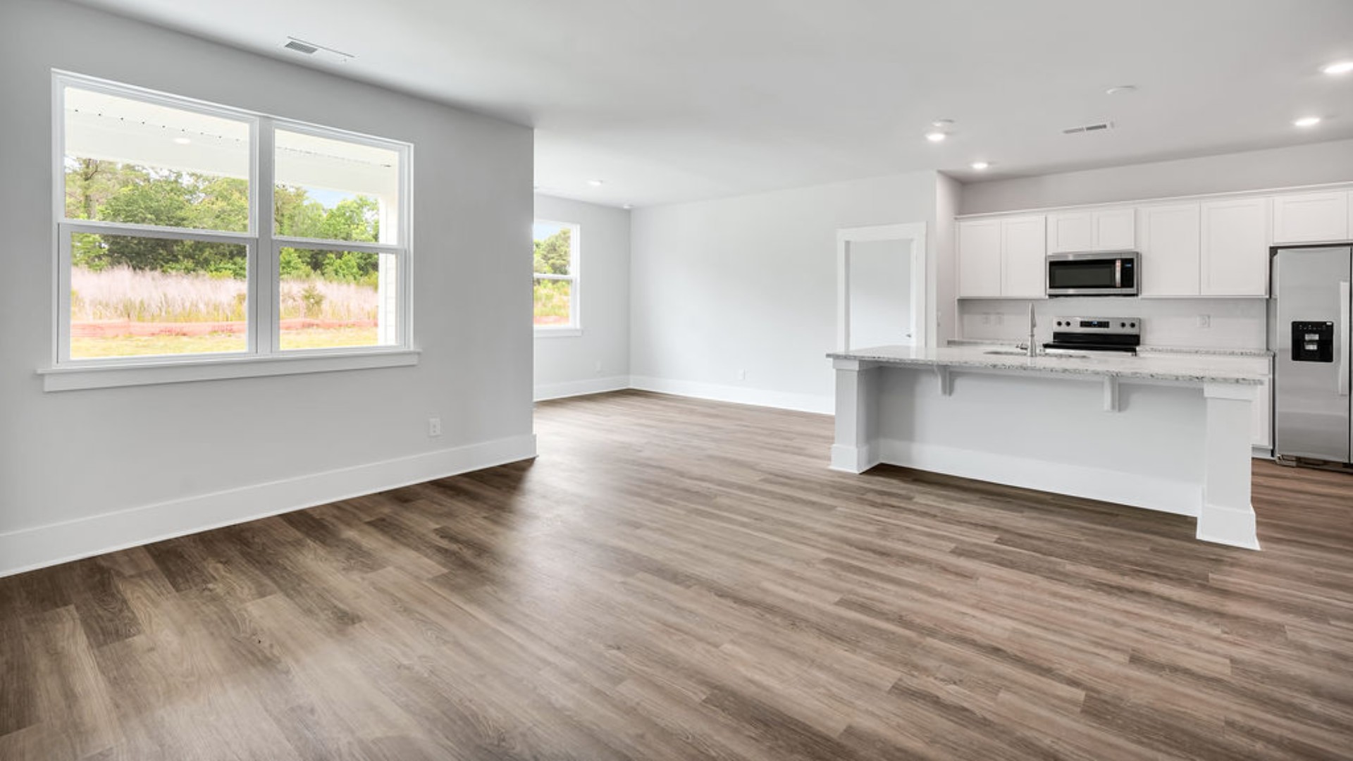 The main living area does not disappoint, by offering plenty of room to gather with family and friends. The kitchen includes a walk-in pantry, stainless-steel appliances, and a large island for bar seating.