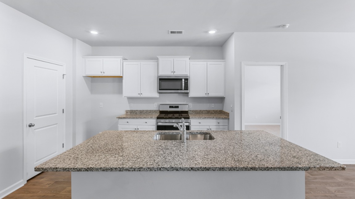 The main living area does not disappoint, by offering plenty of room to gather with family and friends. The kitchen includes a walk-in pantry, stainless-steel appliances, and a large island for bar seating.