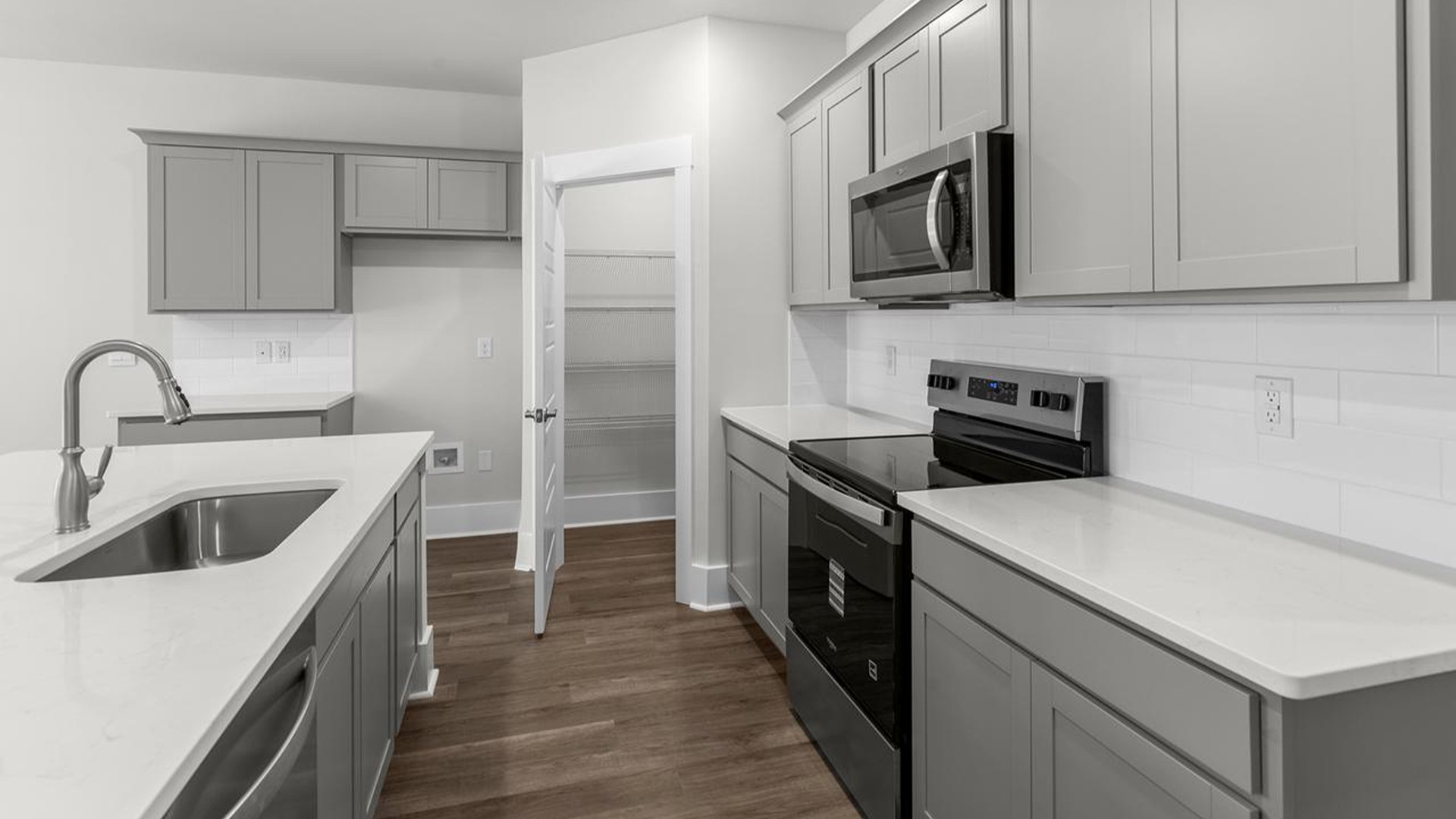 The well-appointed kitchen is equipped with modern appliances, walk-in pantry, and center island, perfect for both cooking and casual dining.