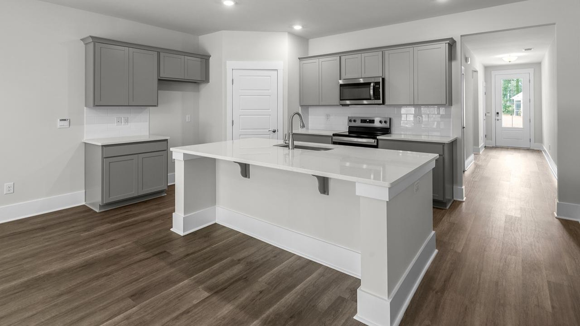 The well-appointed kitchen is equipped with modern appliances, walk-in pantry, and center island, perfect for both cooking and casual dining.