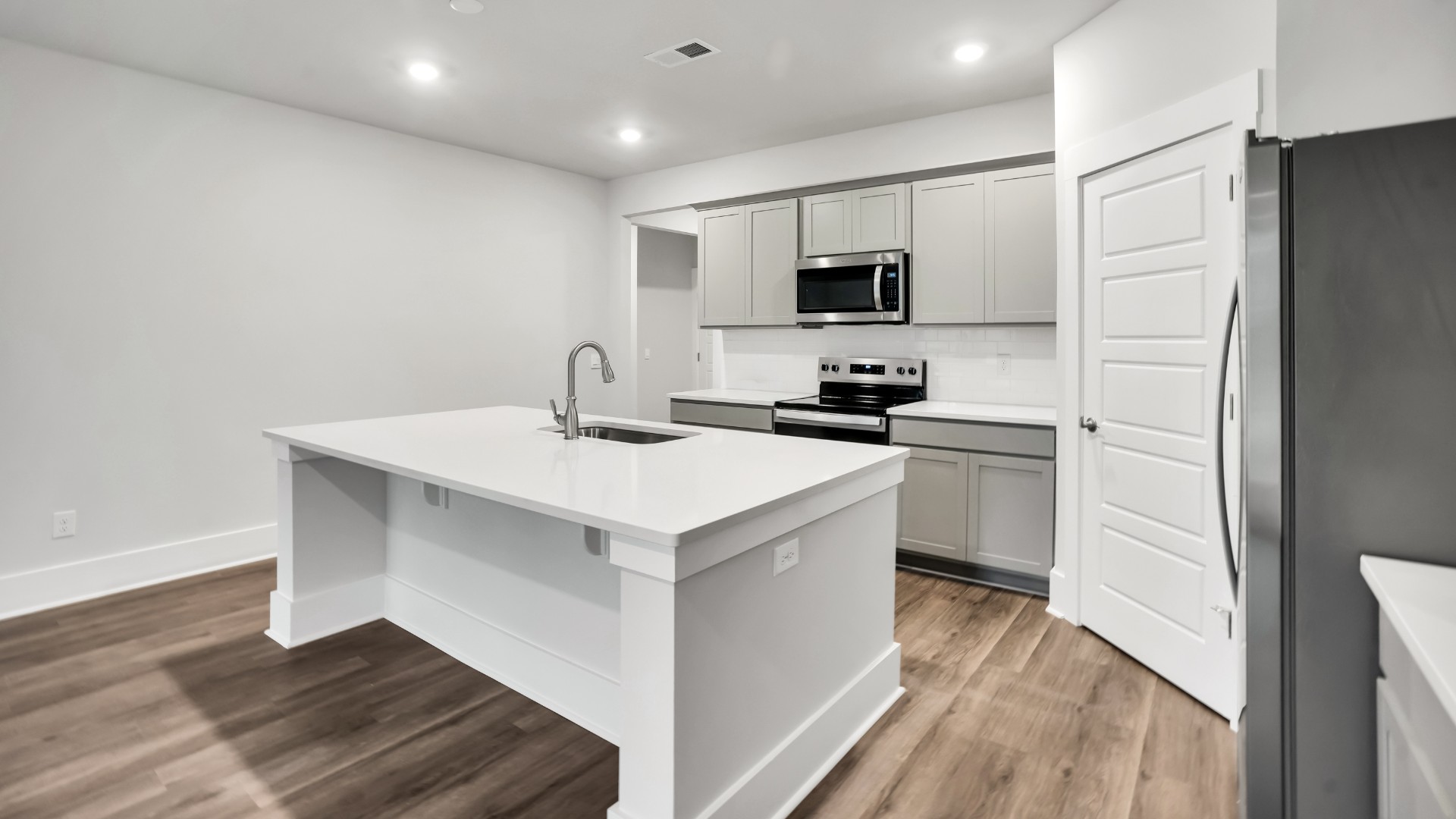 The well-appointed kitchen is equipped with modern appliances, walk-in pantry, and center island, perfect for both cooking and casual dining.