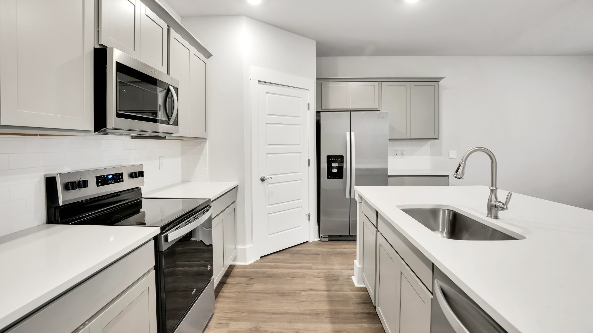 The well-appointed kitchen is equipped with modern appliances, walk-in pantry, and center island, perfect for both cooking and casual dining