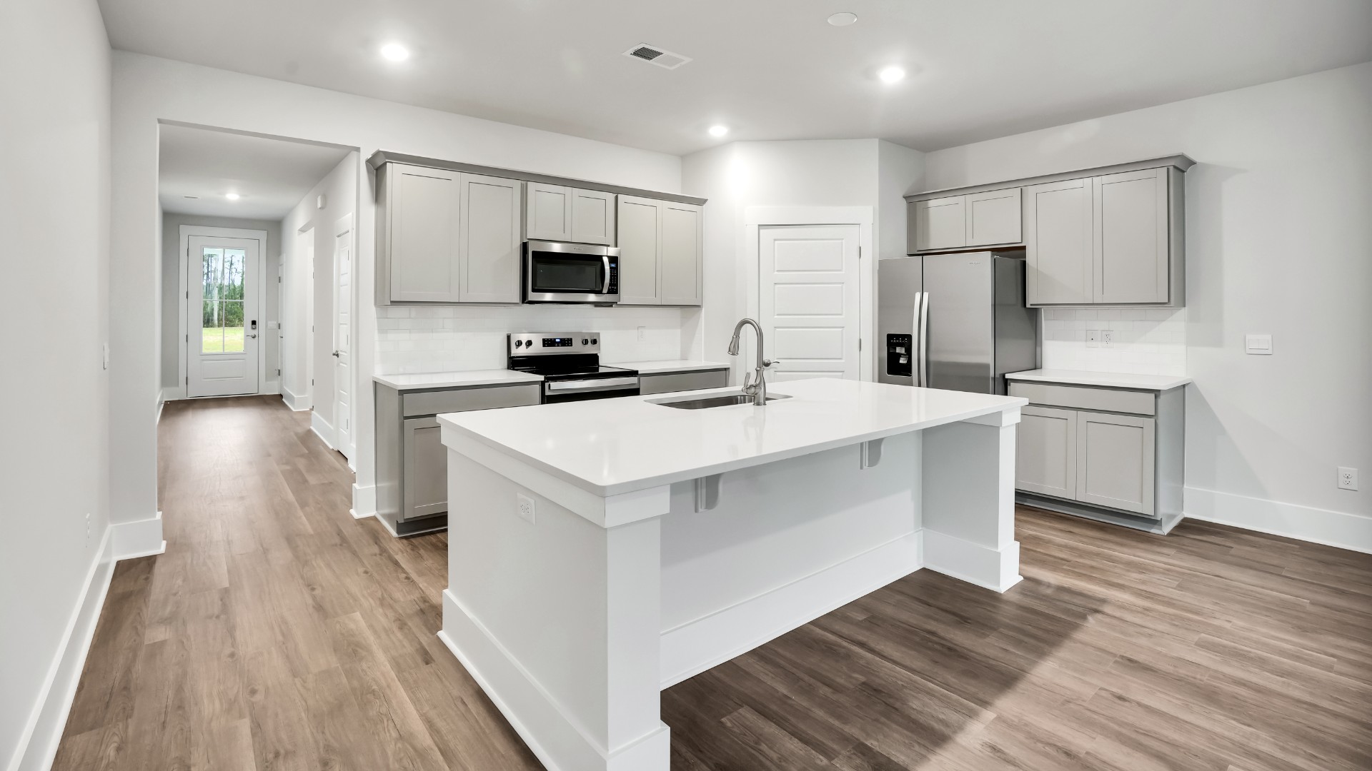The well-appointed kitchen is equipped with modern appliances, walk-in pantry, and center island, perfect for both cooking and casual dining