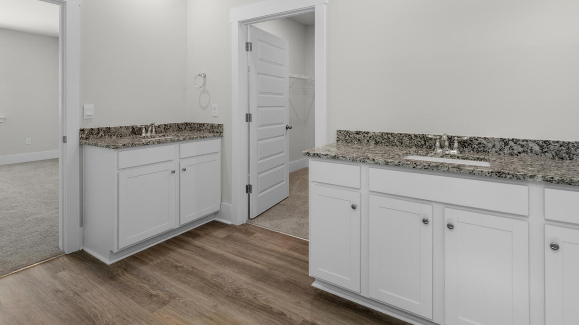The primary suite as well as on suite is sure to impress with double vanities and a massive walk-in closet., a large, covered porch for those nice breezy sunsets! LVP floors are installed throughout the home as well as the stain resistant carpets that add comfort to the bedrooms.