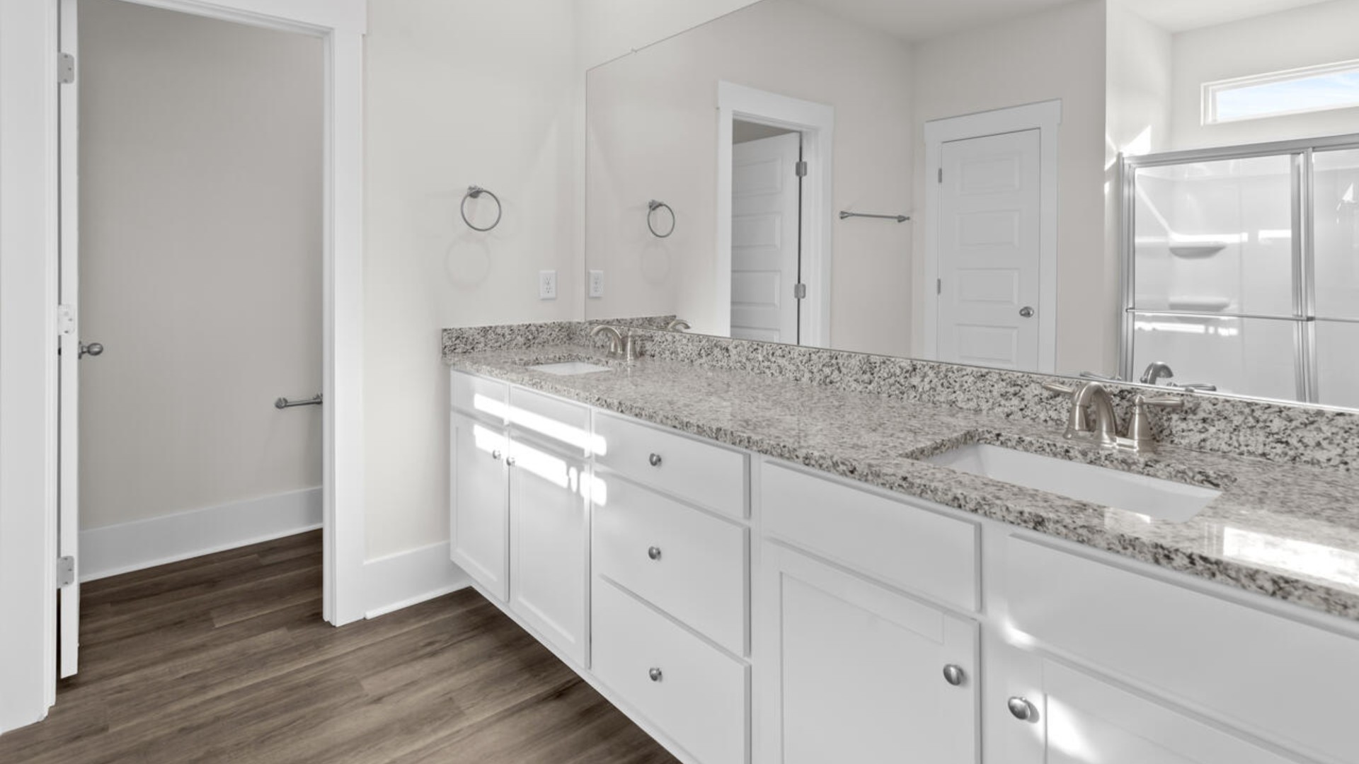 The split bedroom plan creates a private primary bedroom suite featuring two walk-in closets and a spacious en suite bath. There are three bedrooms at the front of the home with a full bathroom as well as laundry room.