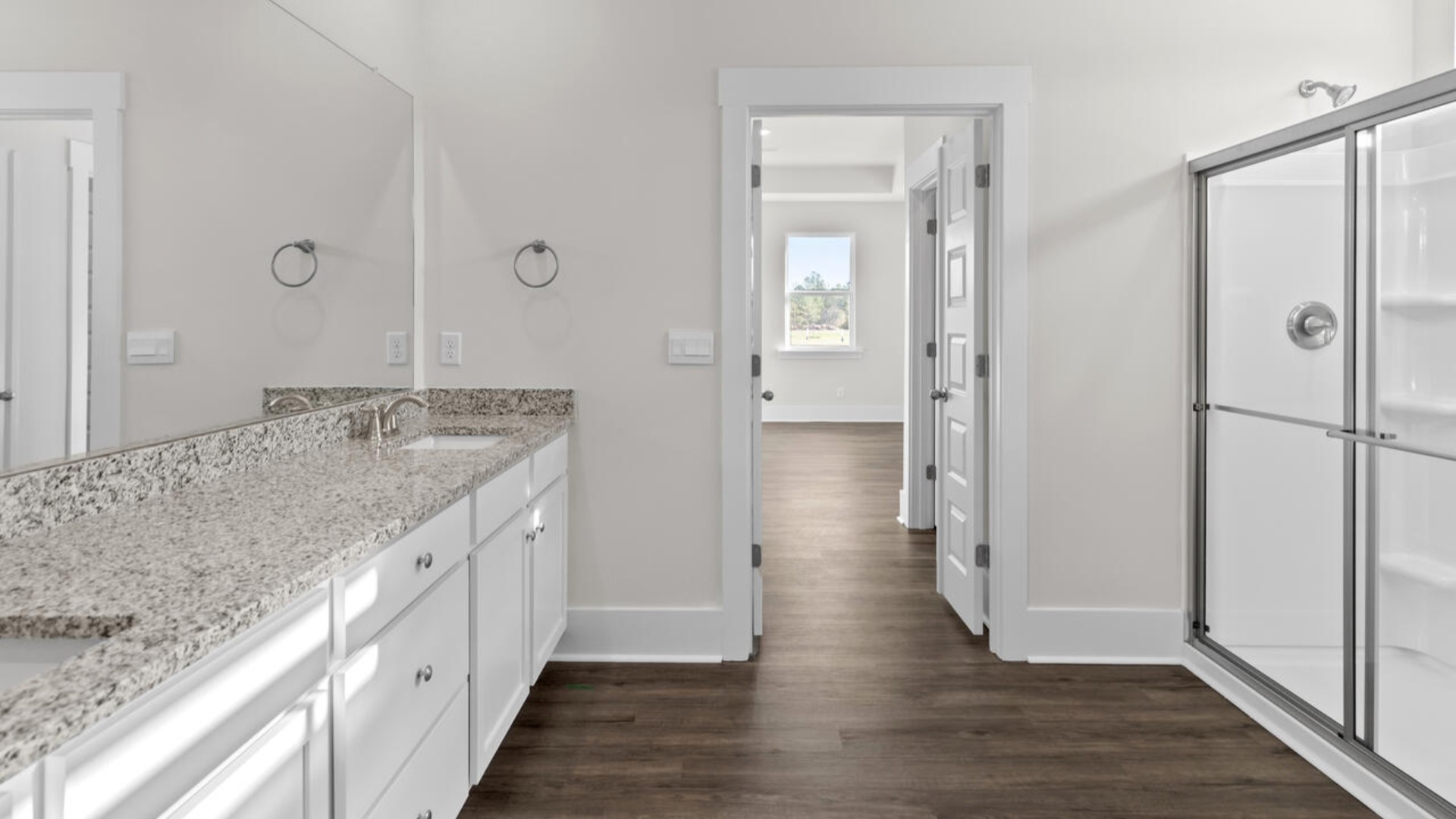 The split bedroom plan creates a private primary bedroom suite featuring two walk-in closets and a spacious en suite bath. There are three bedrooms at the front of the home with a full bathroom as well as laundry room.