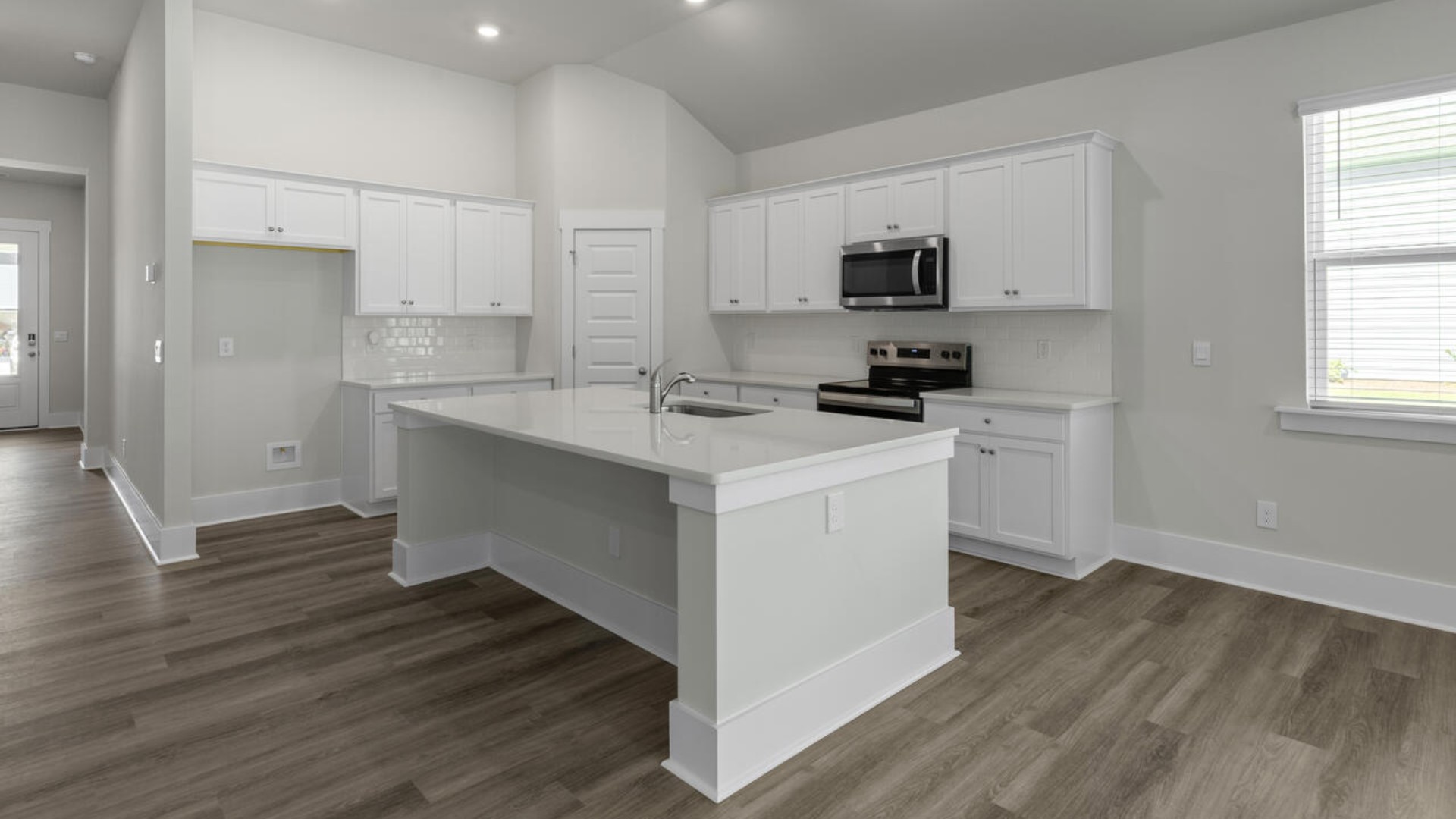 A large gourmet kitchen that features a large island, granite countertops, walk-in pantry, and stainless-steel appliances.