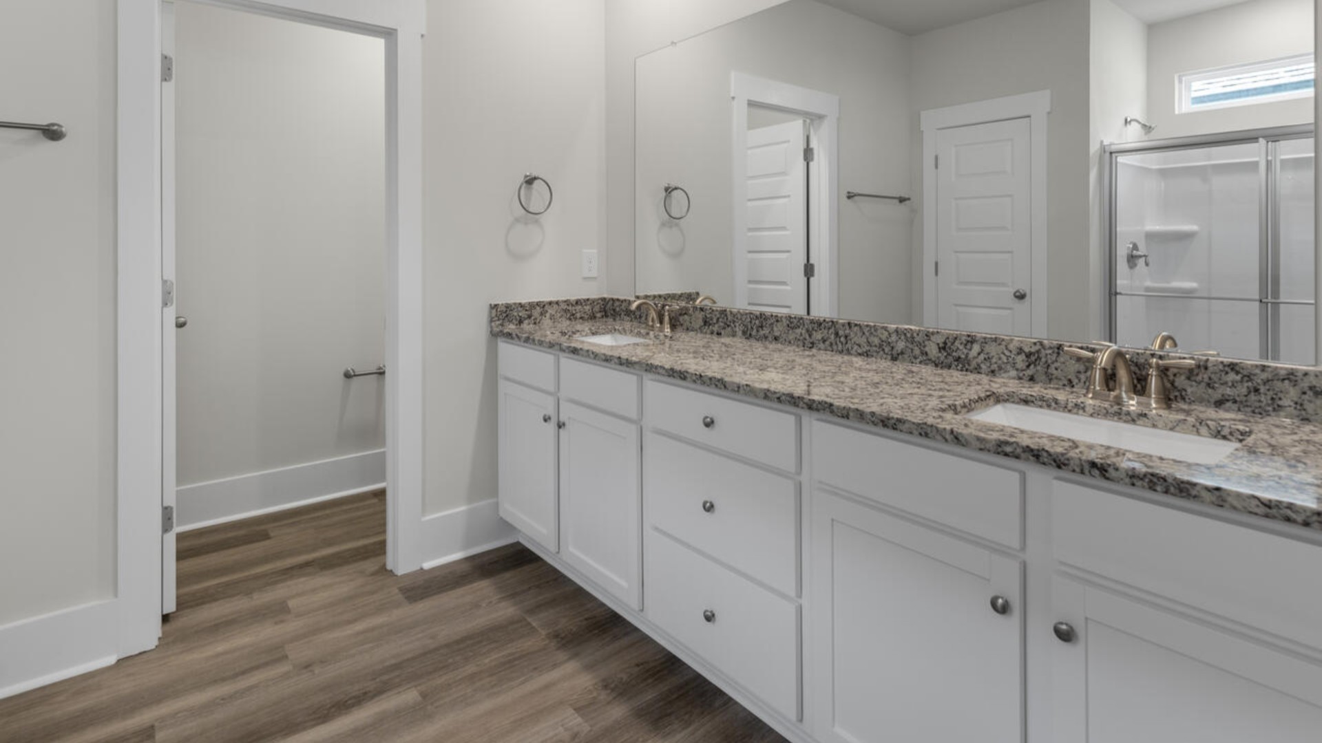 The split bedroom plan creates a private primary bedroom suite featuring two walk-in closets and a spacious en suite bath.