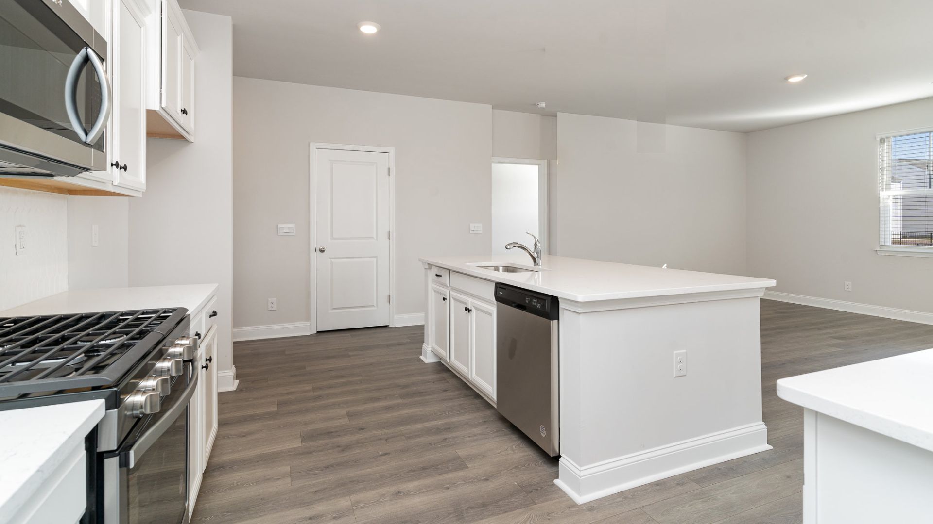 The kitchen features shaker-style cabinets, quartz countertops, and stainless steel appliances, which are sure to both turn heads and make meal prep easy. You’ll never be too far from the action with the living and dining area right there.