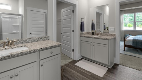 The primary suite as well as on suite is sure to impress with double vanities and a massive walk-in closet., a large, covered porch for those nice breezy sunsets! LVP floors are installed throughout the home as well as the stain resistant carpets that add comfort to the bedrooms.