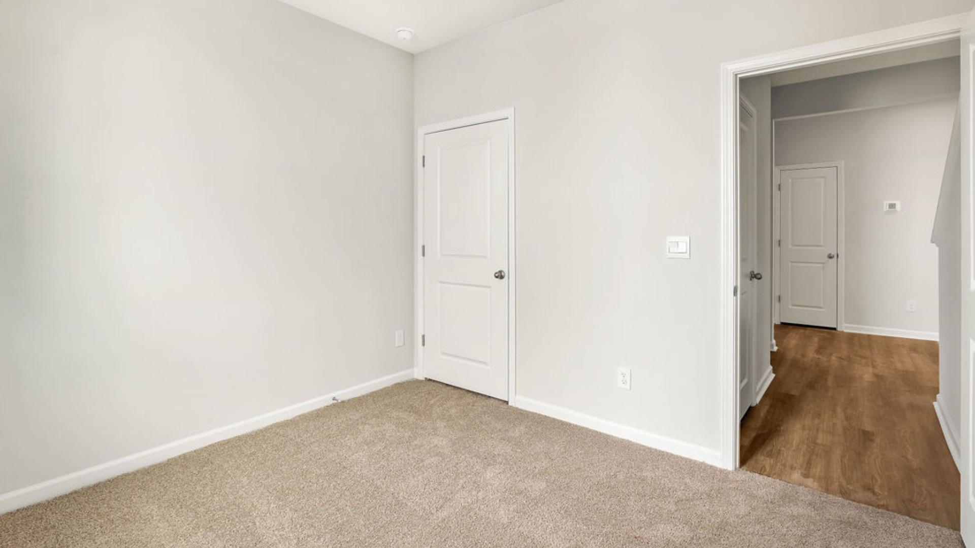 There is a bedroom at the front of the home and two additional main-floor bedrooms, and a shared full bathroom sit near the front of the home.