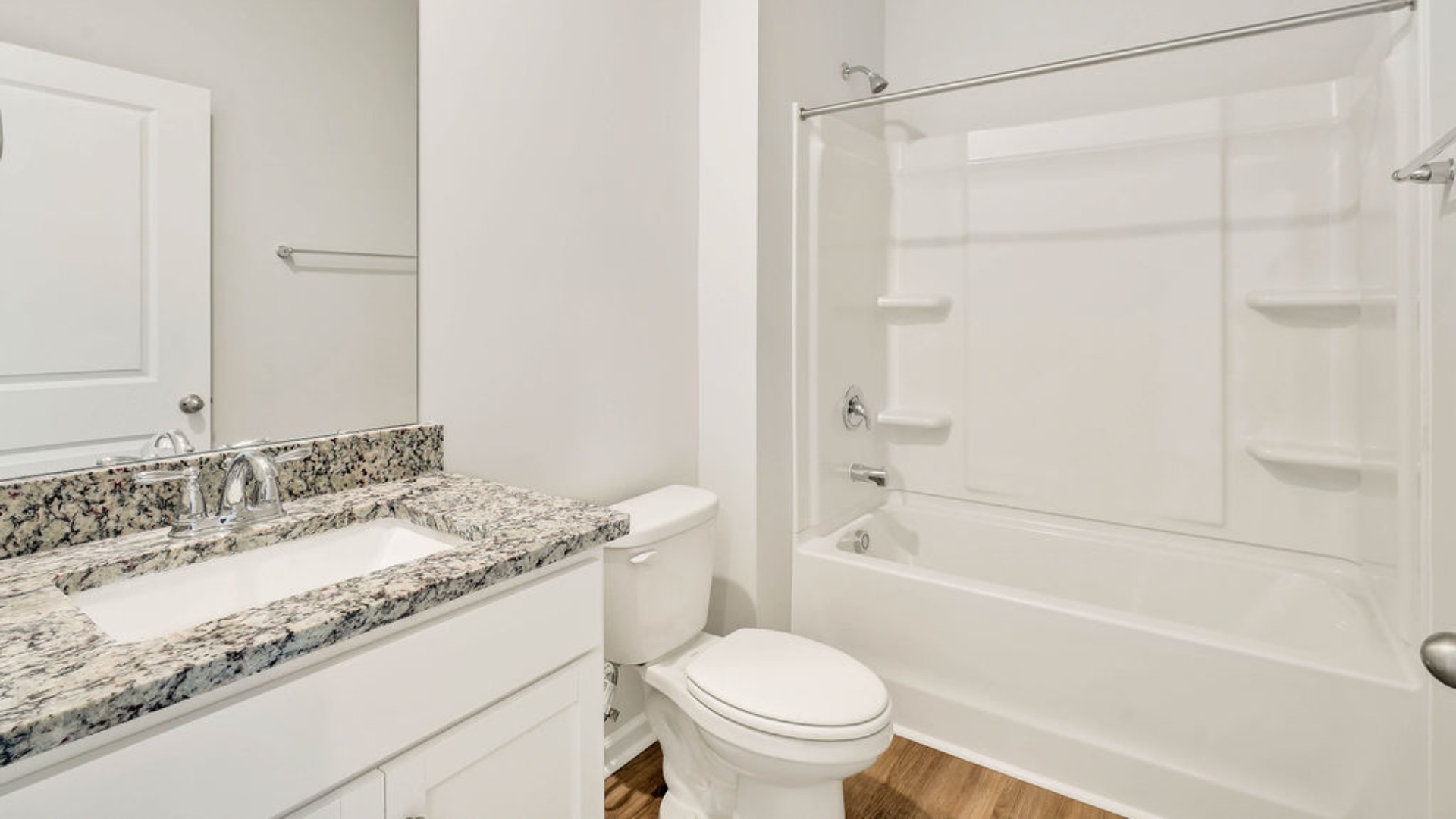 There is a bedroom at the front of the home and two additional main-floor bedrooms, and a shared full bathroom sit near the front of the home.