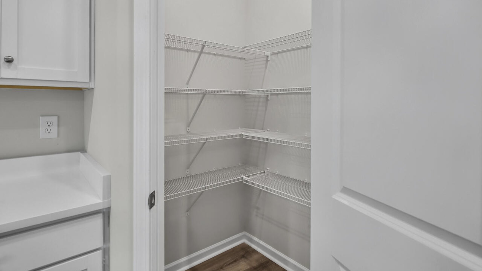 A large gourmet kitchen with 42'' cabinets and granite, walk-in pantry, and stainless-steel appliances in kitchen.