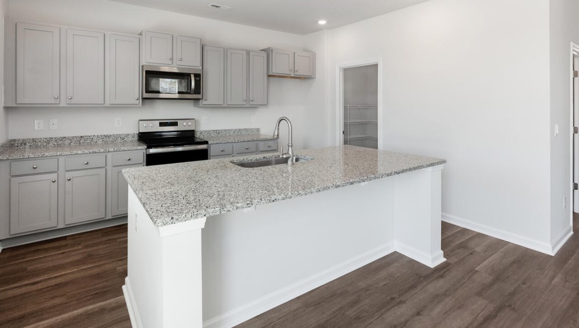 The kitchen features shaker-style cabinets, granite countertops, and stainless-steel appliances, which are sure to both turn heads and make meal prep easy.