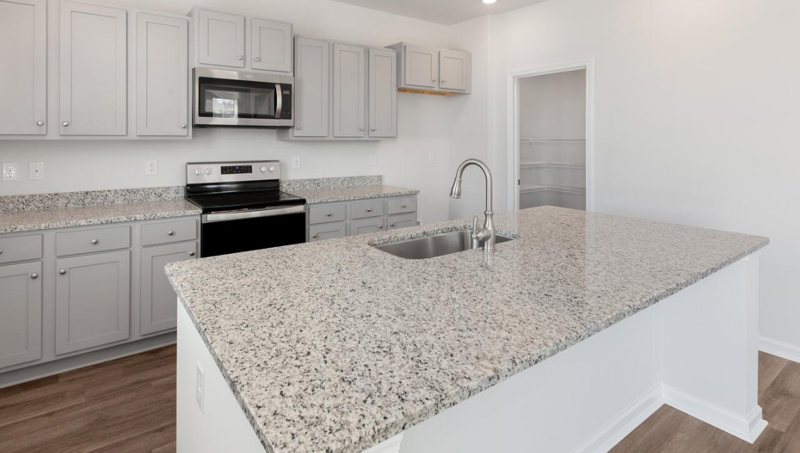 The kitchen features shaker-style cabinets, granite countertops, and stainless-steel appliances, which are sure to both turn heads and make meal prep easy.