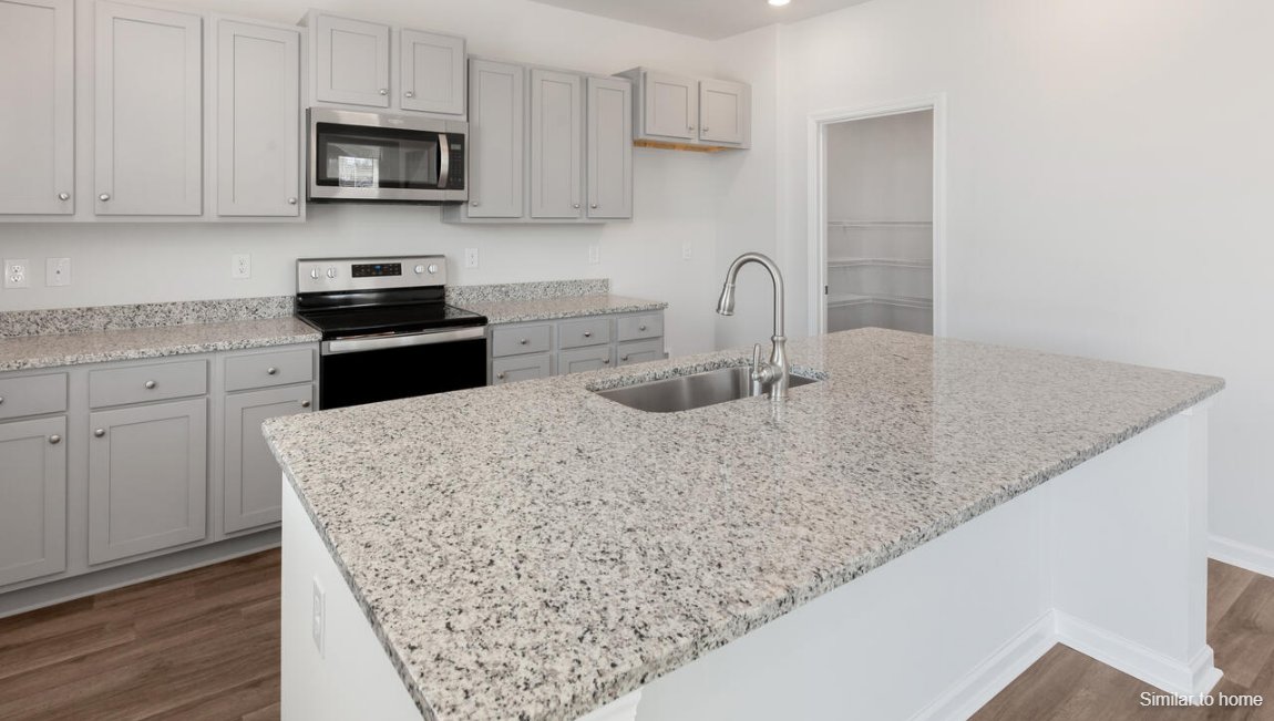 The kitchen features shaker-style cabinets, granite countertops, and stainless-steel appliances, which are sure to both turn heads and make meal prep easy. You’ll never be too far from the action with the living and dining area right there.