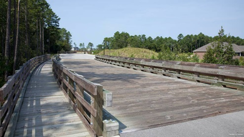 Residents have access to a range of amenities such as a well-equipped clubhouse, a fitness room, a spacious competition swimming pool, a kiddie pool, a hot tub, a sports court, a playground, and picturesque nature trails for walking.