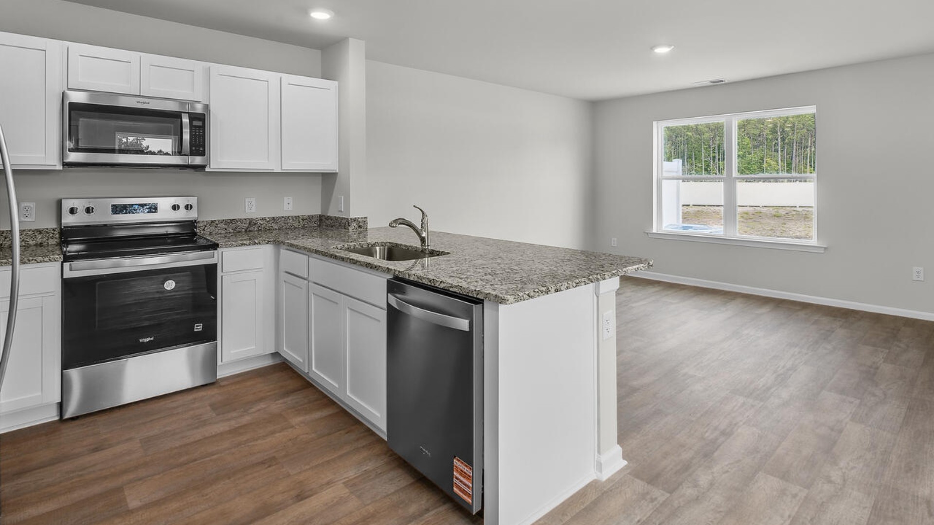 The kitchen overlooks the dining and living spaces, ideal for entertaining guests or enjoying family time while preparing meals with new stainless-steel appliances and Granite countertops.