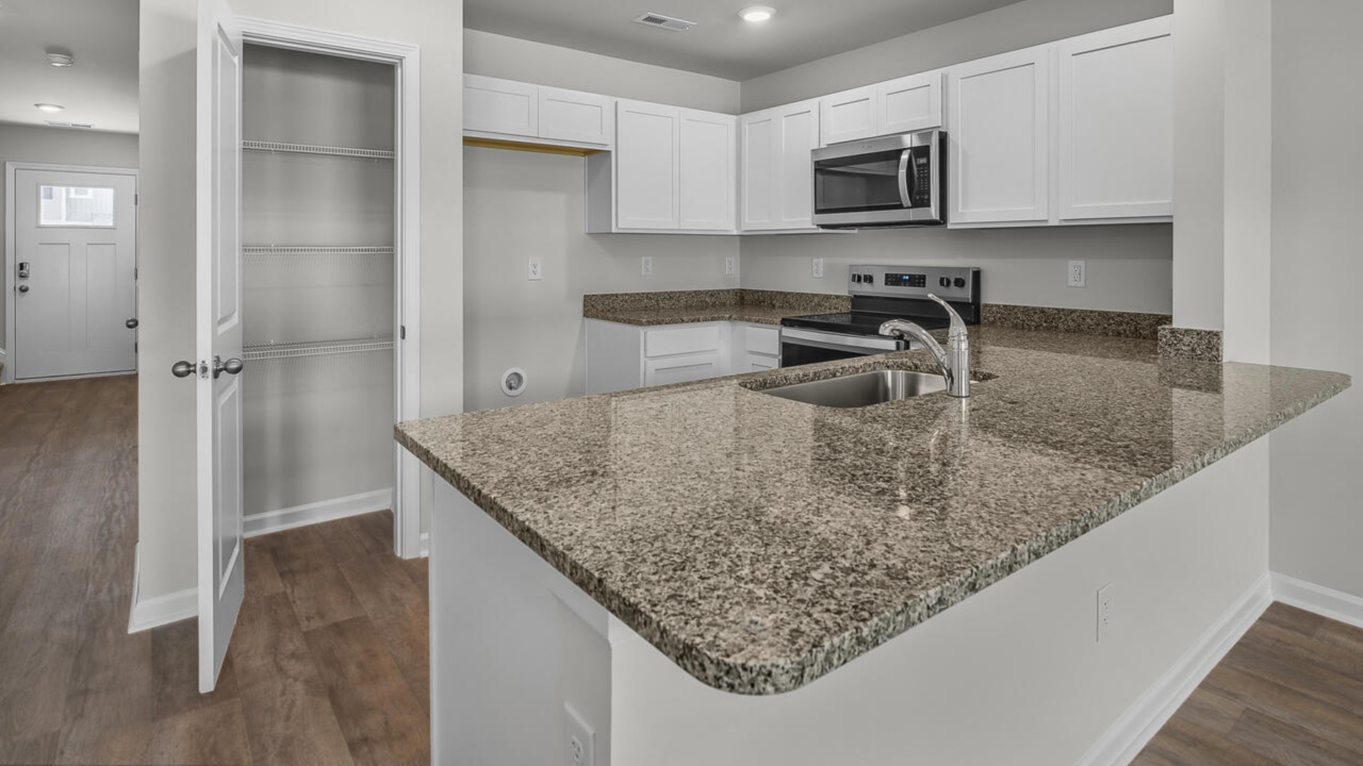 The kitchen overlooks the dining and living spaces, ideal for entertaining guests or enjoying family time while preparing meals with new stainless-steel appliances and Granite countertops.