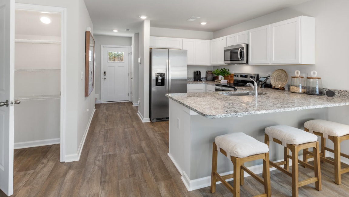 The first floor features a spacious primary bedroom, offering convenience and privacy. The luxury kitchen is equipped with elegant granite countertops and soft-closing cabinets.