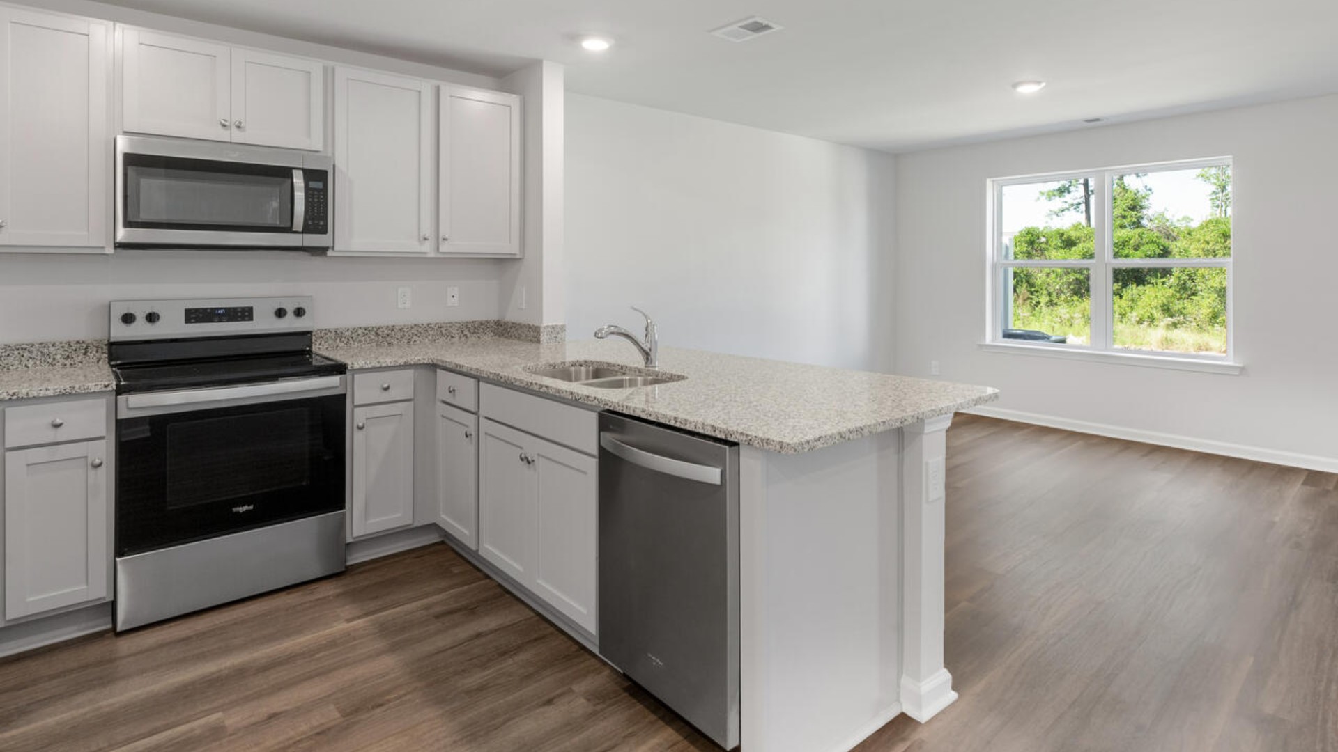 The kitchen overlooks the dining and living spaces, ideal for entertaining guests or enjoying family time while preparing meals with new stainless-steel appliances and Granite countertops.