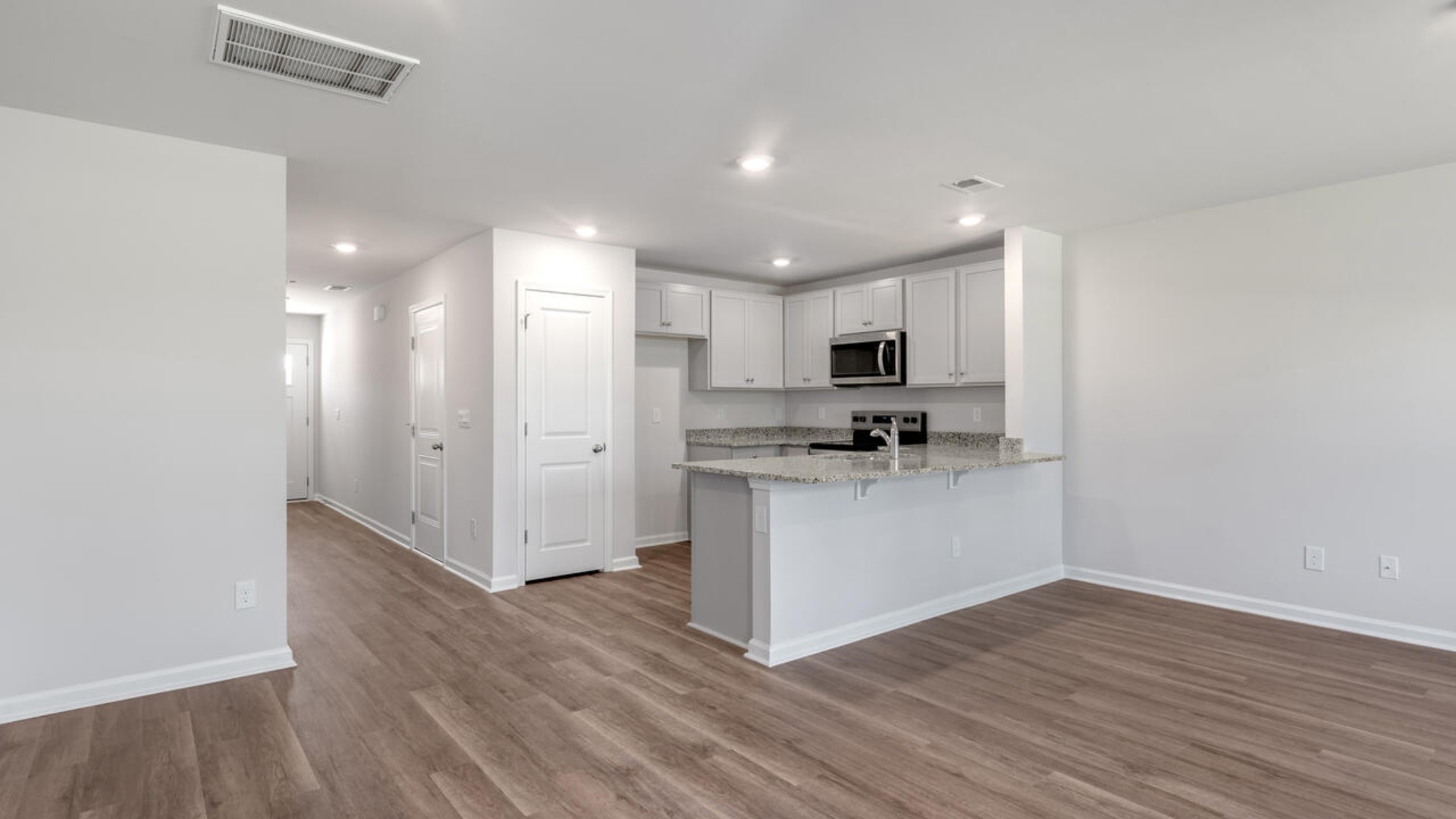 The kitchen overlooks the dining and living spaces, ideal for entertaining guests or enjoying family time while preparing meals with new stainless-steel appliances and Granite countertops.