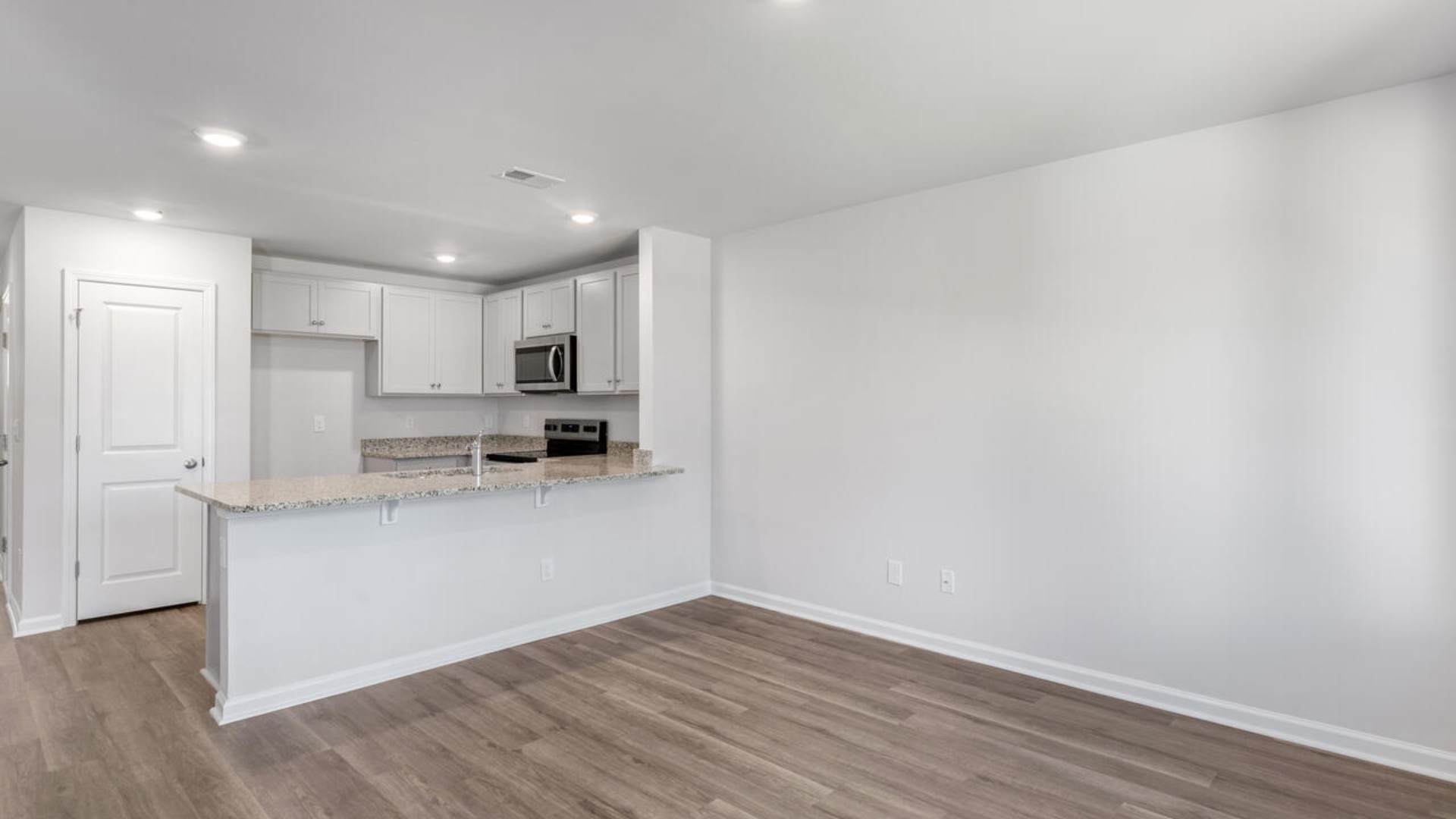 The kitchen overlooks the dining and living spaces, ideal for entertaining guests or enjoying family time while preparing meals with new stainless-steel appliances and Granite countertops.