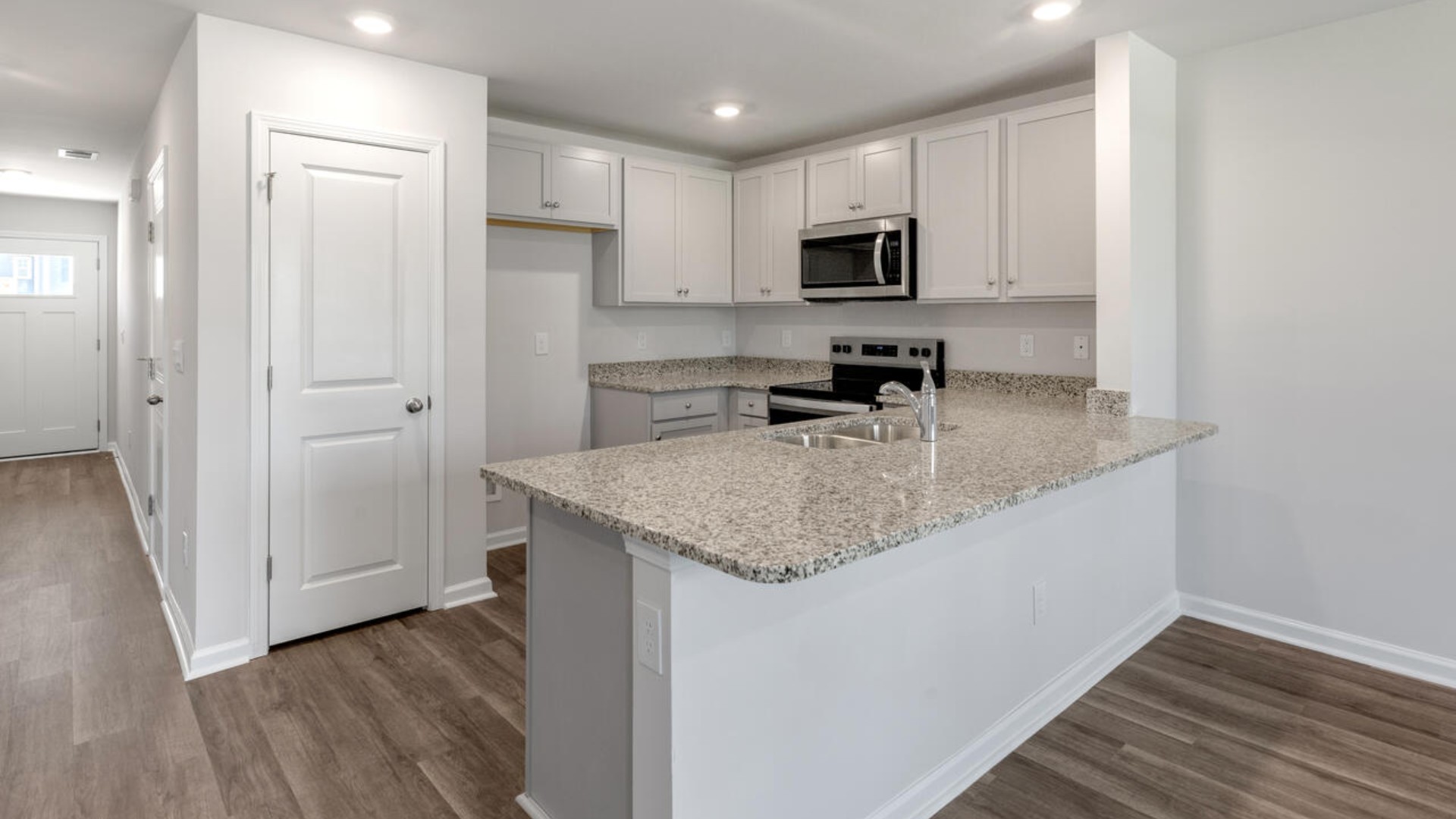 The kitchen overlooks the dining and living spaces, ideal for entertaining guests or enjoying family time while preparing meals with new stainless-steel appliances and Granite countertops.