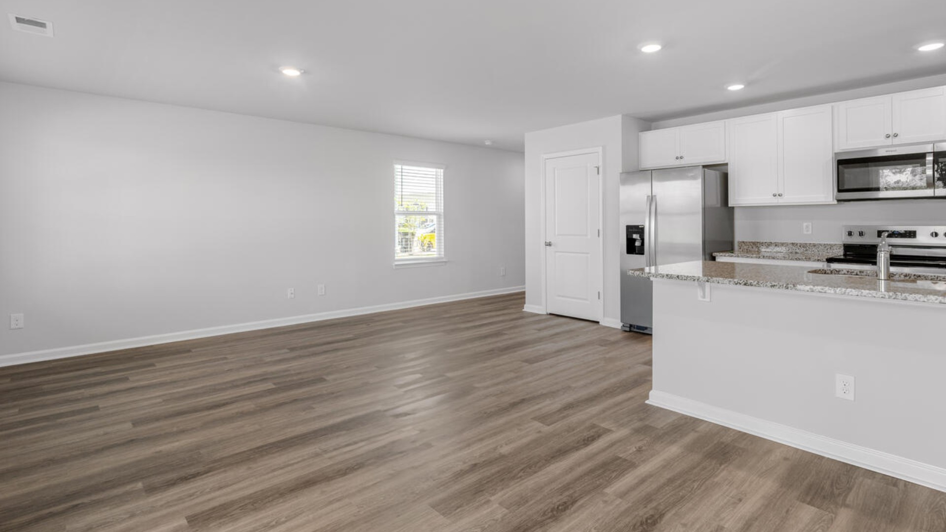 The kitchen features shaker-style cabinets, granite countertops, and stainless steel appliances, which are sure to both turn heads and make meal prep easy. You’ll never be too far from the action with the living and dining area right there.
