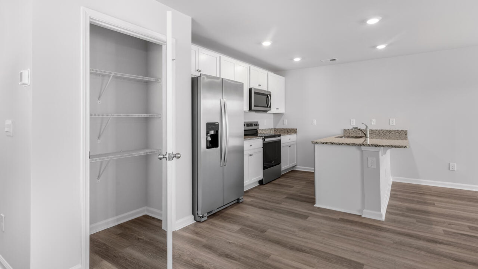 The kitchen features shaker-style cabinets, granite countertops, and stainless steel appliances, which are sure to both turn heads and make meal prep easy. You’ll never be too far from the action with the living and dining area right there.