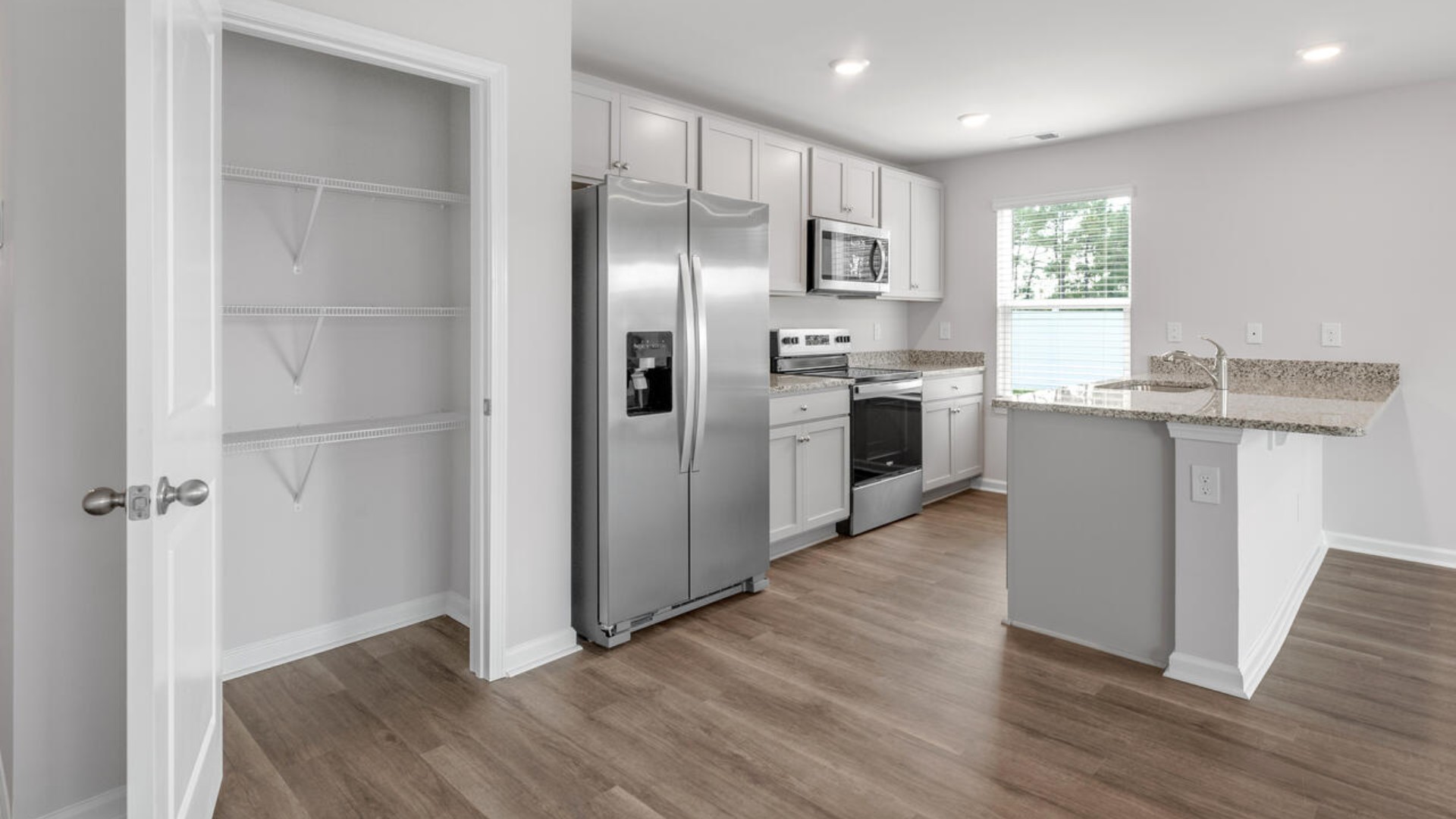 The kitchen features shaker-style cabinets, granite countertops, and stainless steel appliances, which are sure to both turn heads and make meal prep easy.