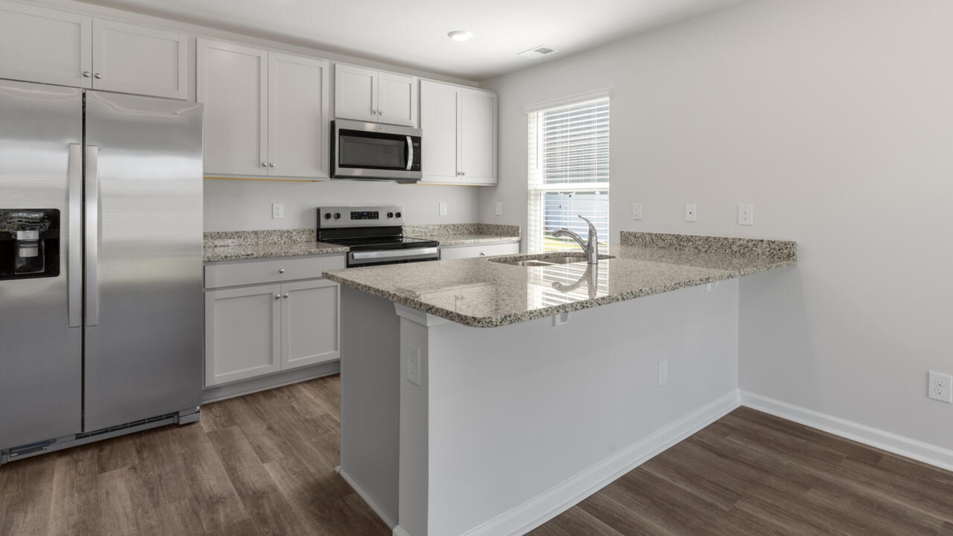 The kitchen features shaker-style cabinets, granite countertops, and stainless steel appliances, which are sure to both turn heads and make meal prep easy.