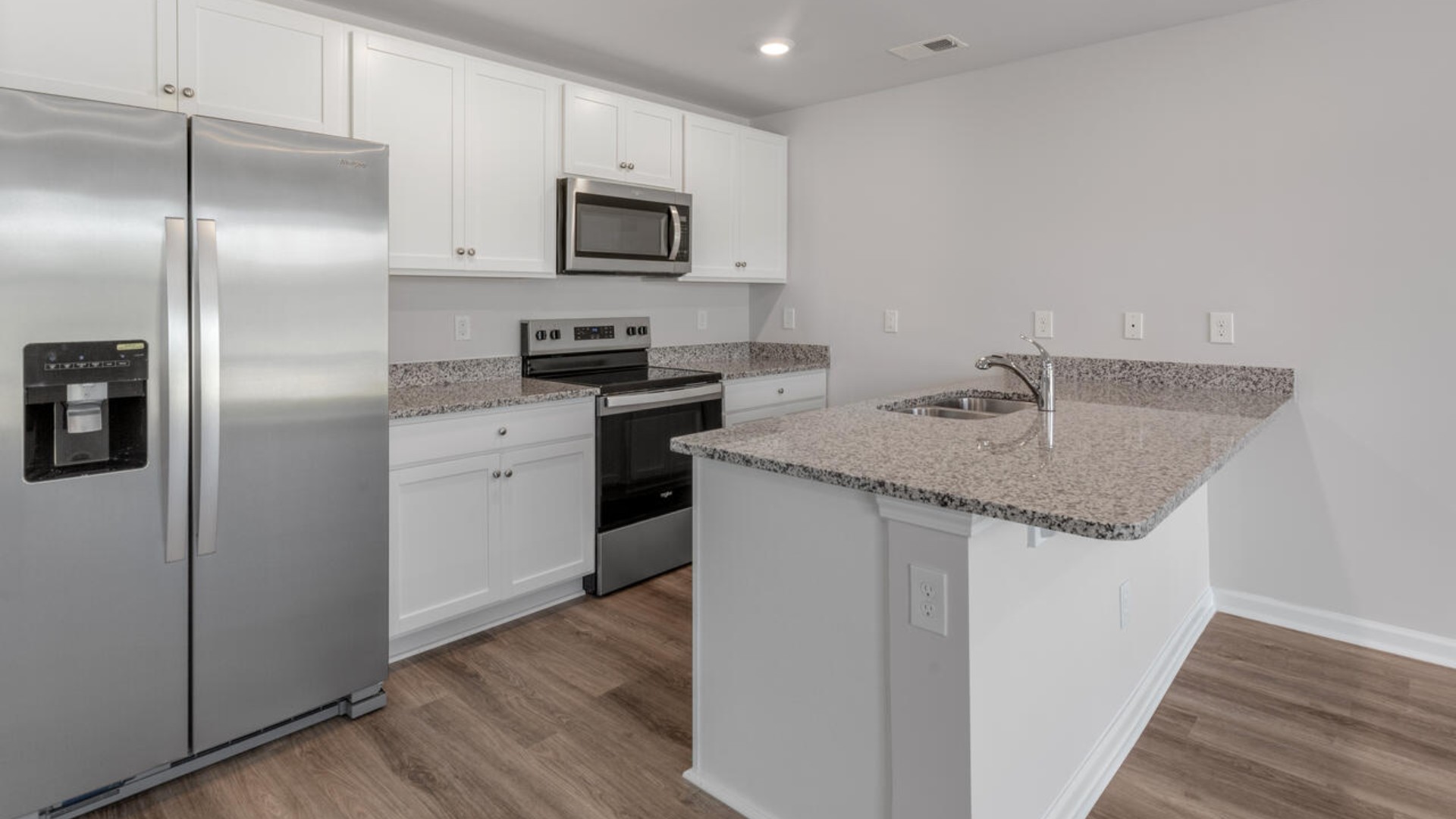 The kitchen features shaker-style cabinets, granite countertops, and stainless steel appliances, which are sure to both turn heads and make meal prep easy.
