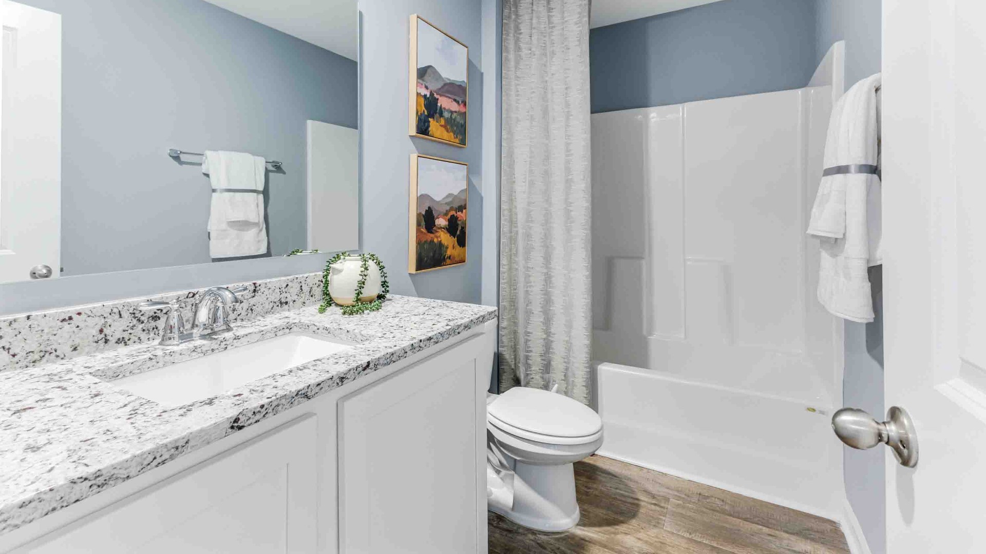 At the back, the Primary Suite provides privacy with a large walk-in closet and walk-in shower. This floor plan combines comfort and convenience, making it a great choice for those seeking an open layout and a 2-car garage.